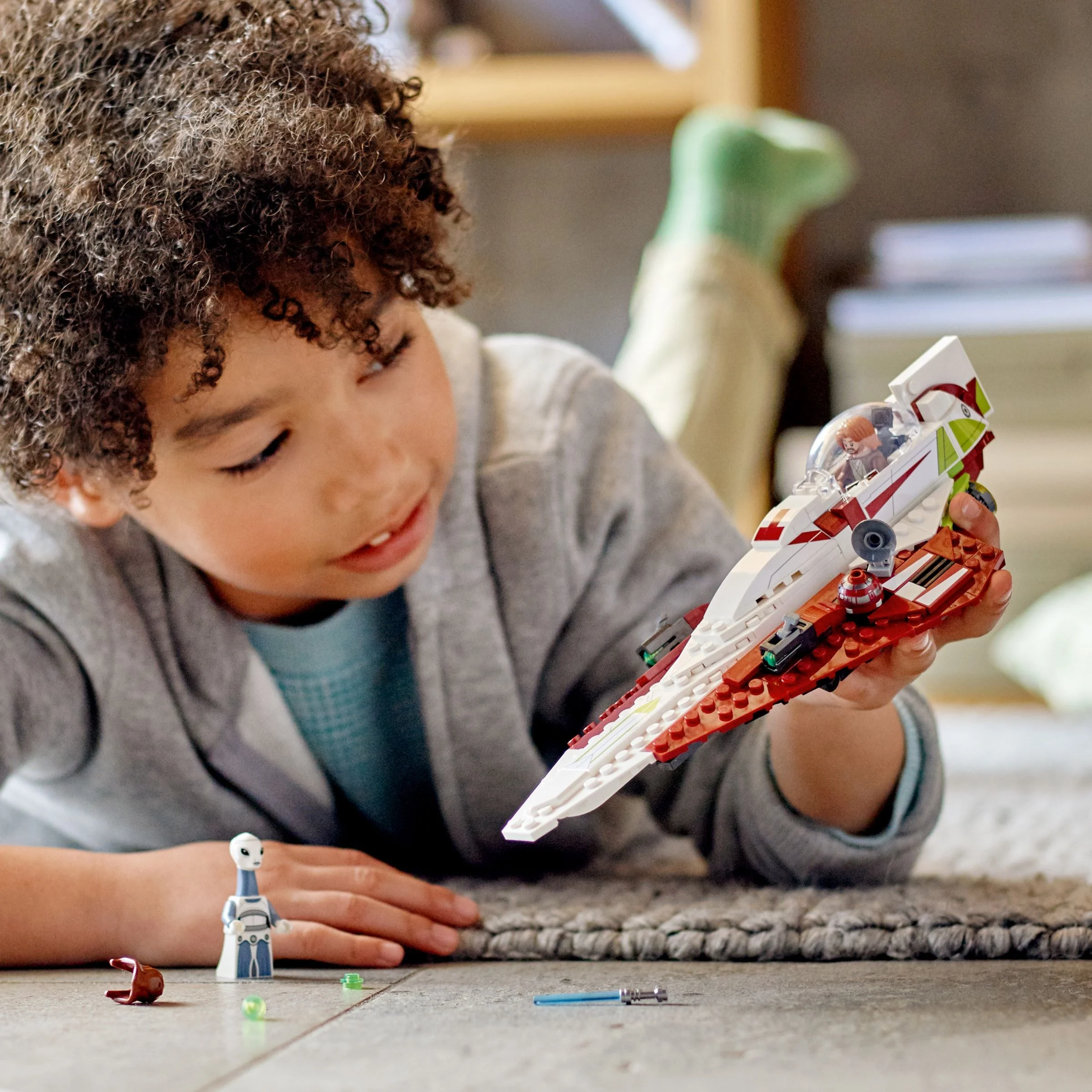 Copil se joacă cu Nava Jedi a lui Obi-Wan Kenobi, setul LEGO 75333.