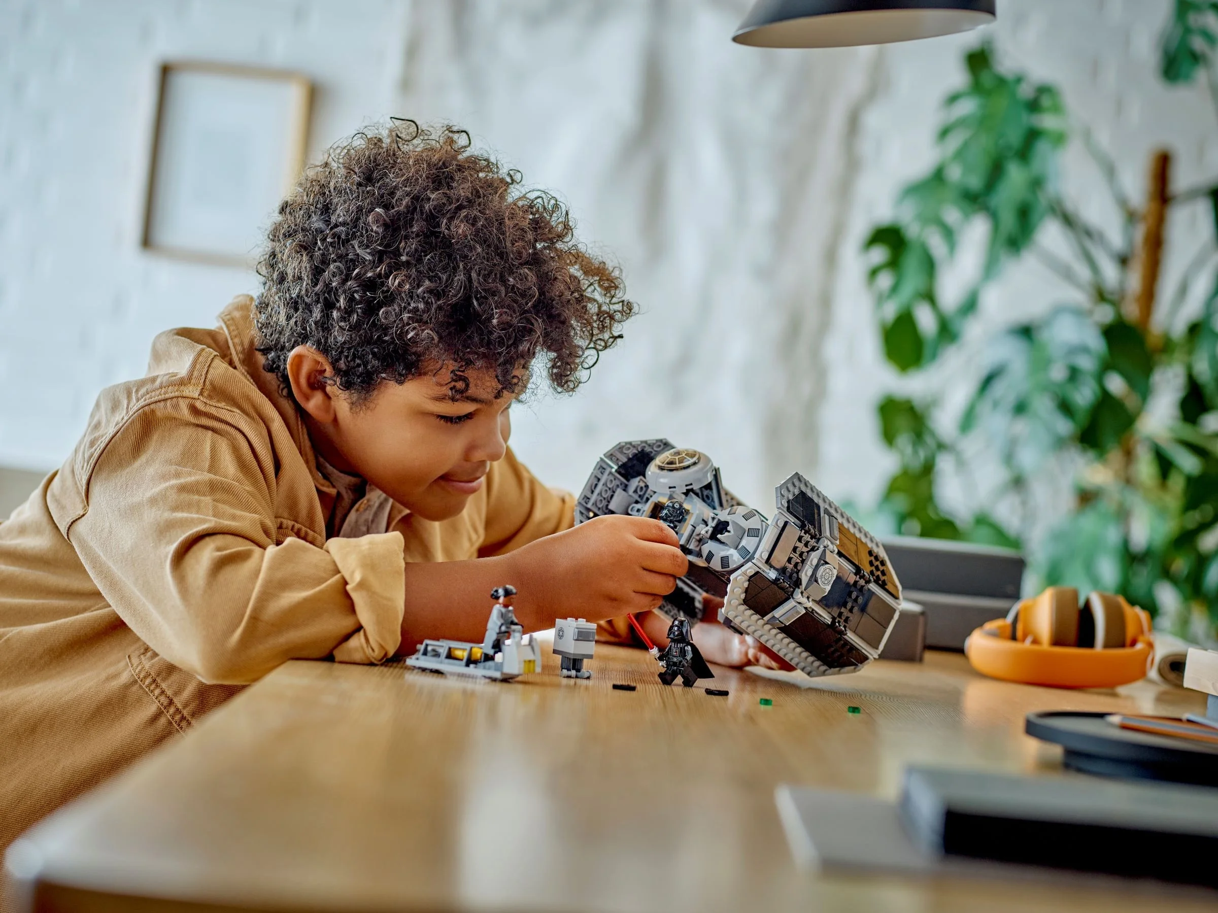 Băiat construind modelul LEGO TIE Bomber (75347), concentrat și entuziasmat.