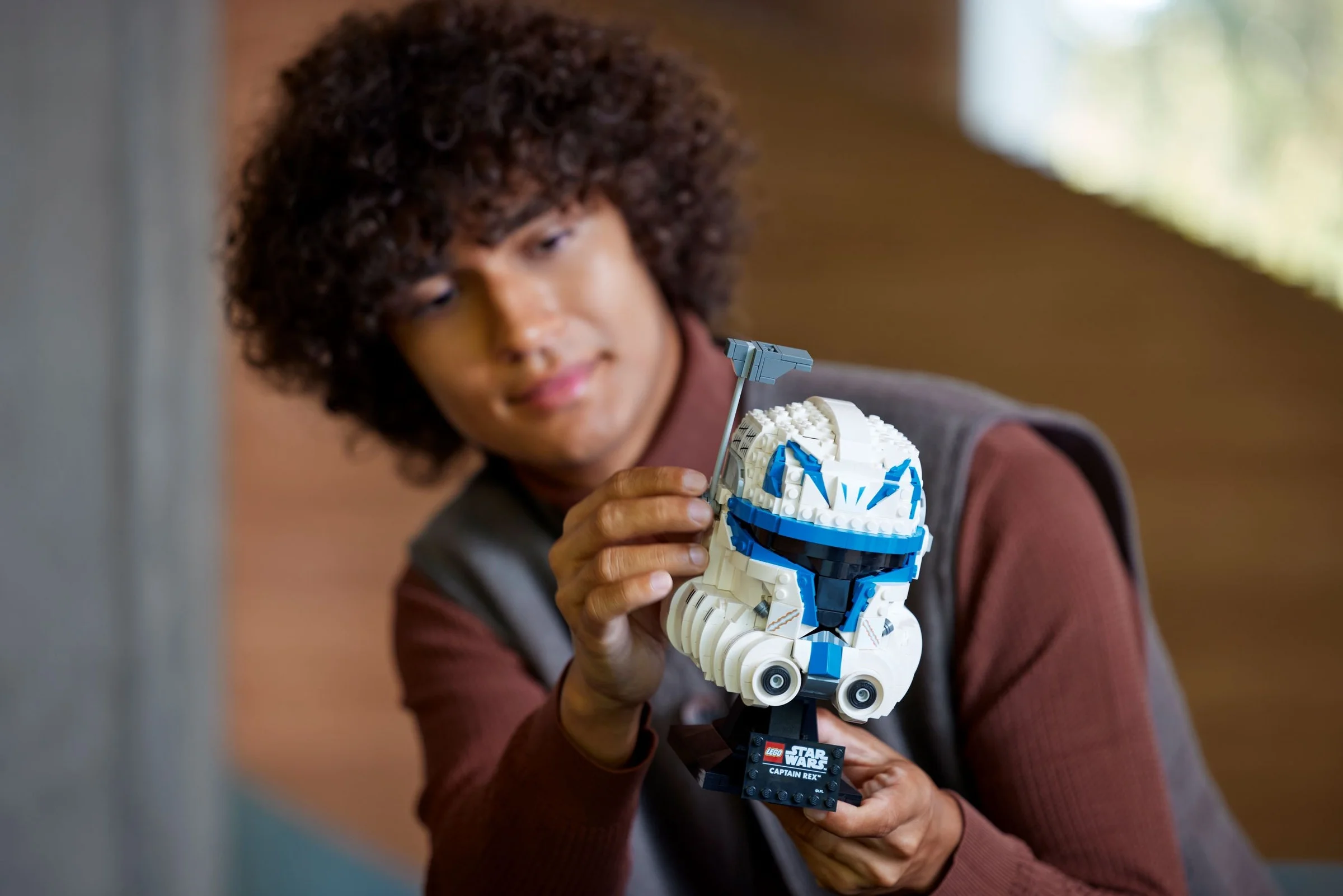 Un tânăr admiră casca LEGO Captain Rex, detaliată și realistă. Un model grozav!