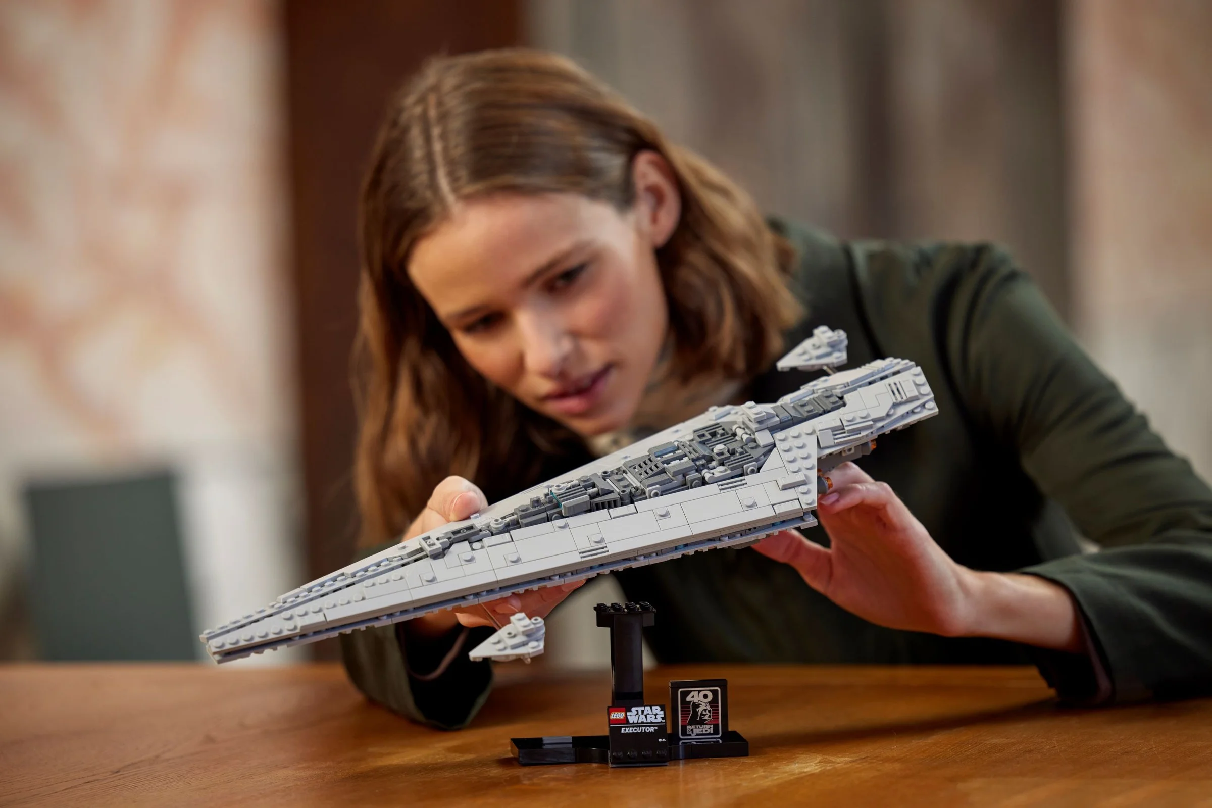 Femeie admirând Executor Super Star Destroyer LEGO. Model detaliat, scenă lifestyle.
