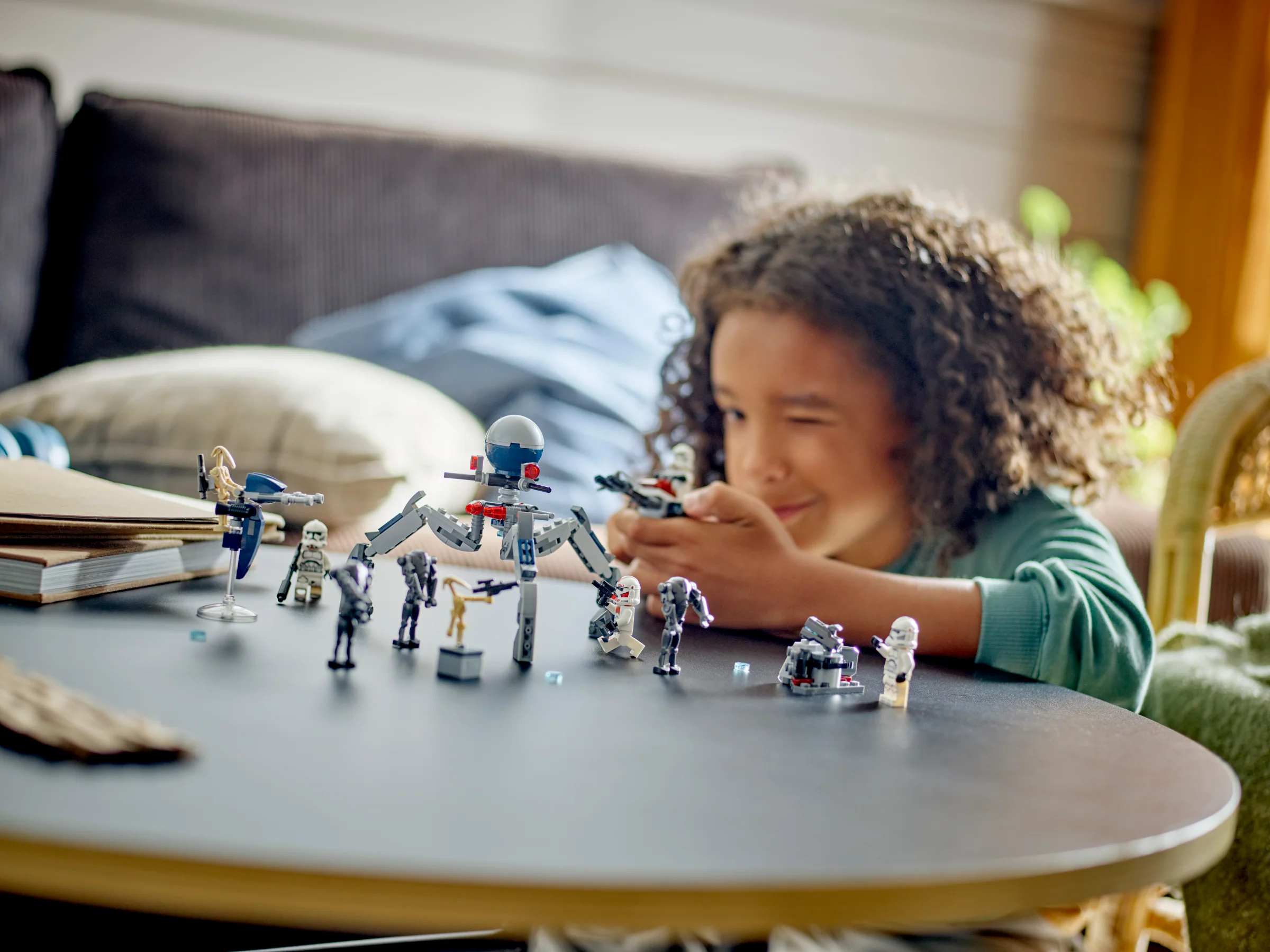 Copil se joacă cu setul LEGO Star Wars 75372, clone și droizi în bătălie. Imagine luminoasă, plină de bucurie.