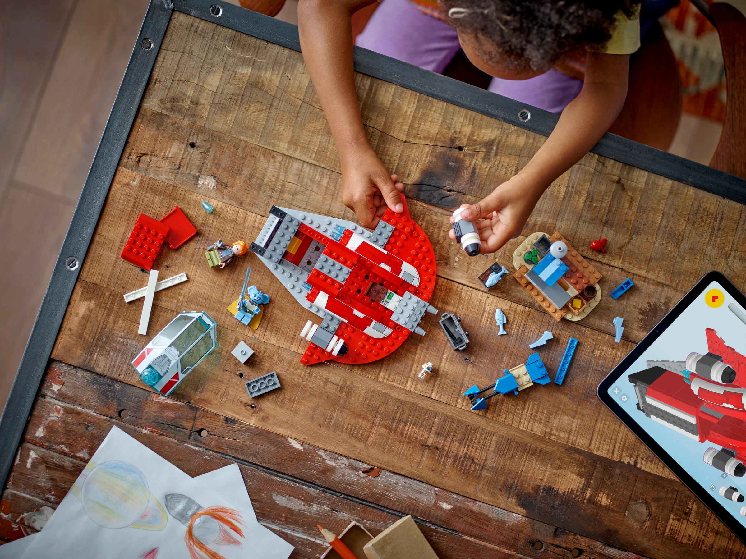 Imagine cu o fetiță construind Crimson Firehawk, setul LEGO Star Wars 75384.