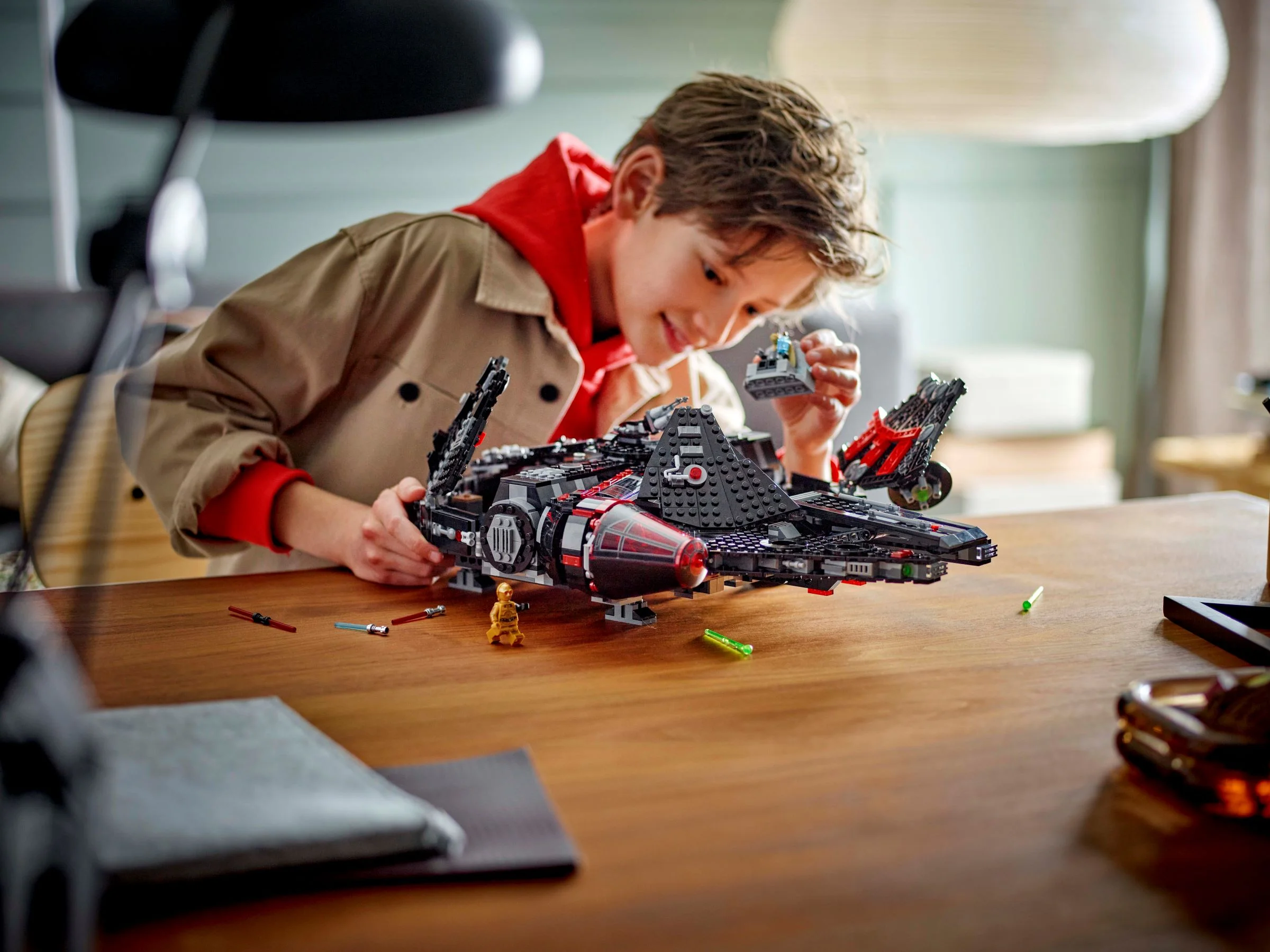 Copil construind setul LEGO 75389, The Dark Falcon. Distracție cu minifigurine și navă spațială.