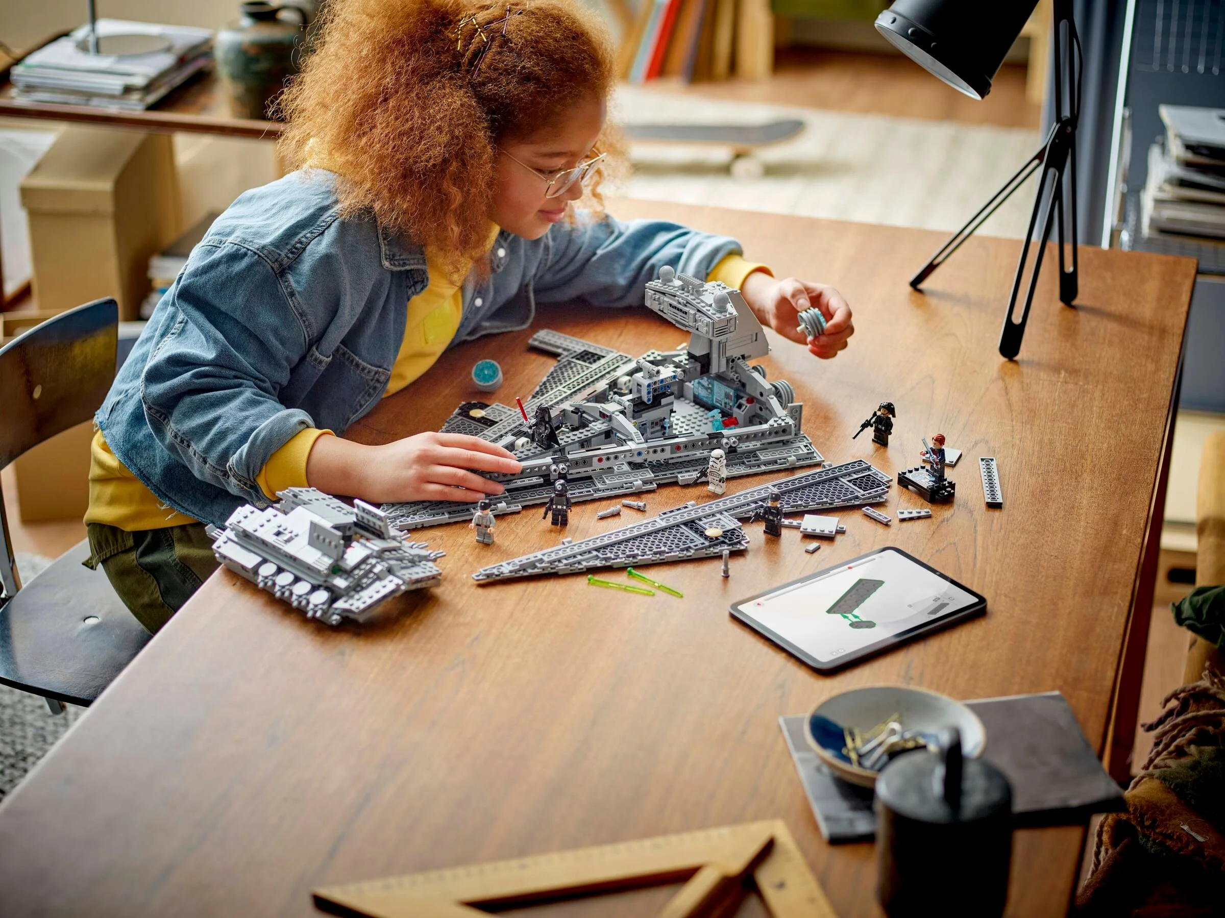 Copil construind setul LEGO Imperial Star Destroyer, o activitate creativă captivantă.