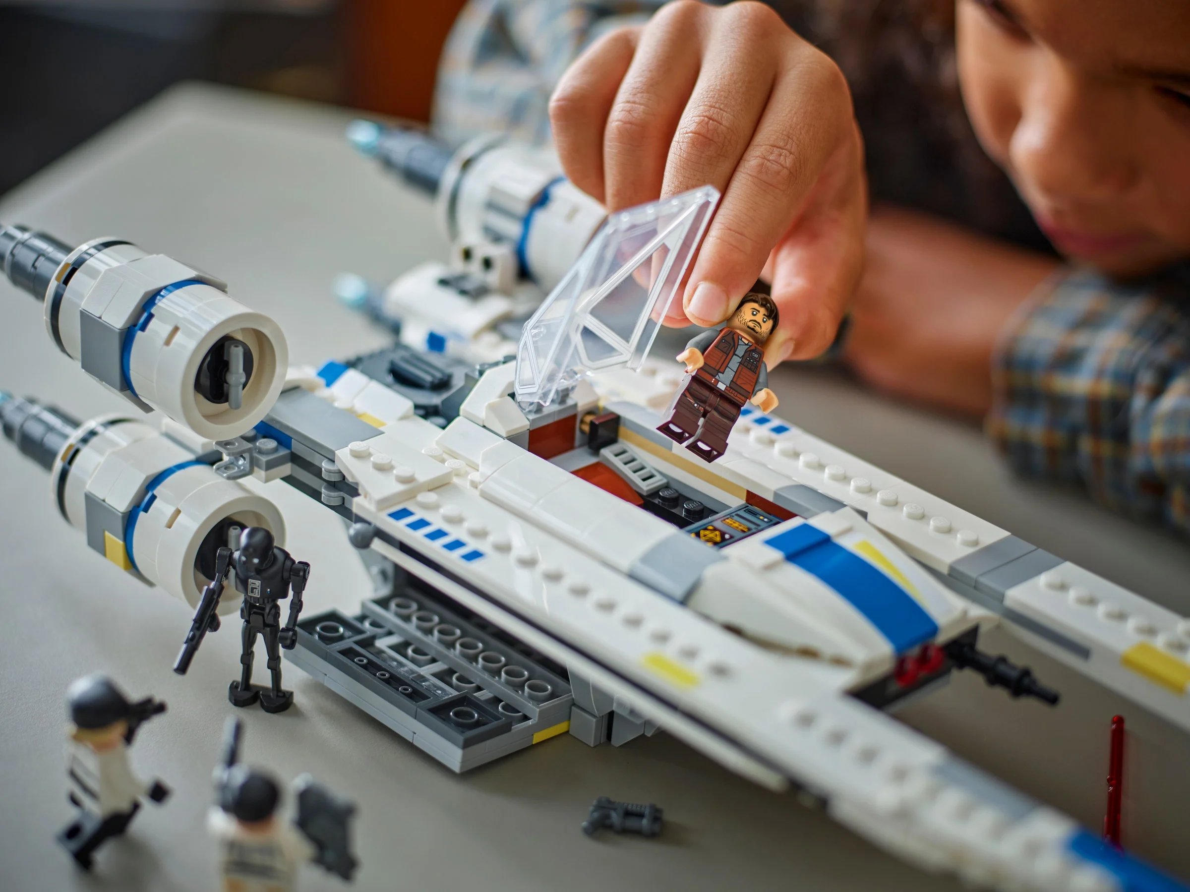 Copil pune minifigurina în U-wing Starfighter. Detaliu al cabinei și al fuselajului.