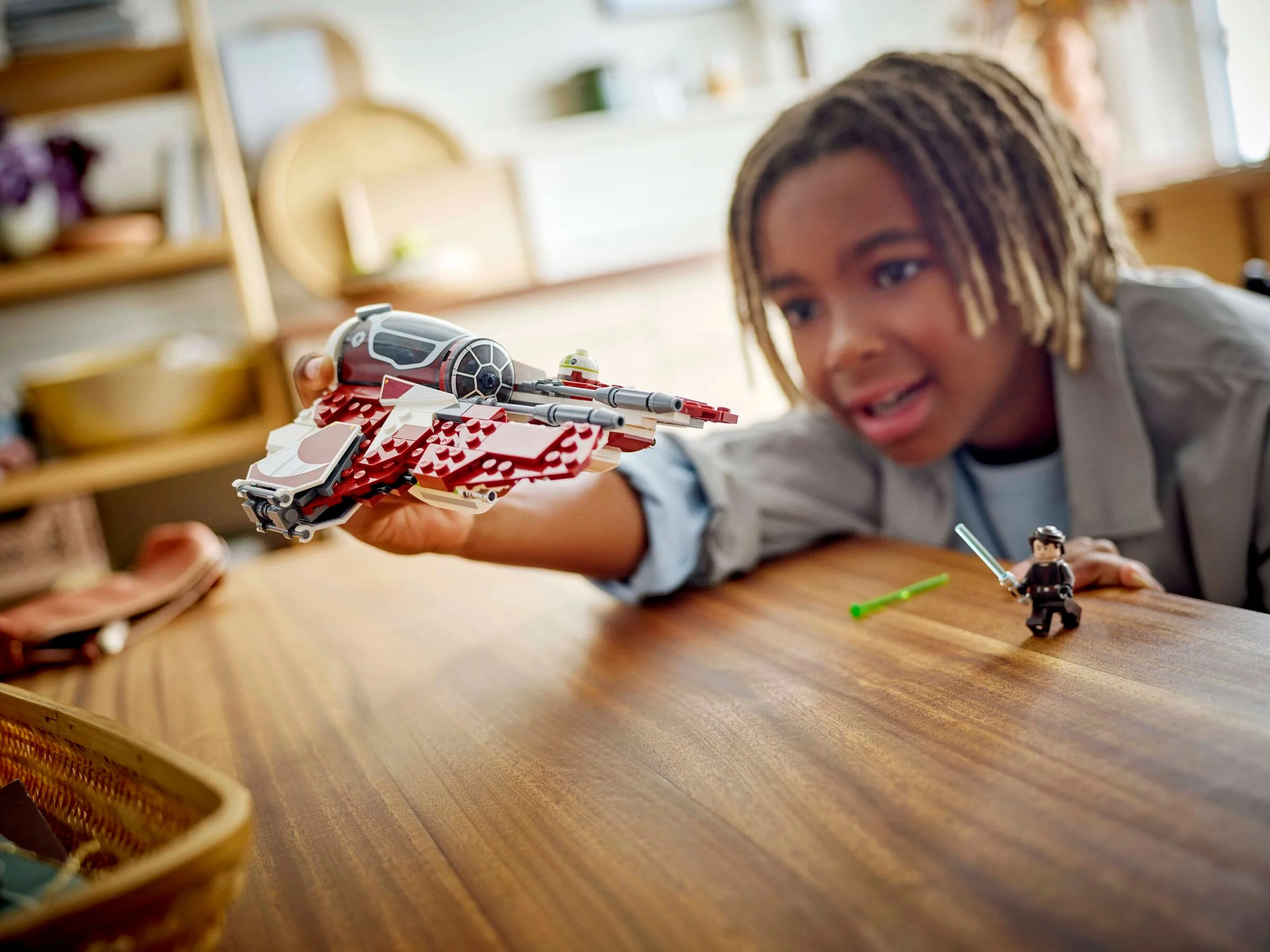 Un copil se joacă cu interceptorul Jedi Ahsoka, un model LEGO Star Wars.