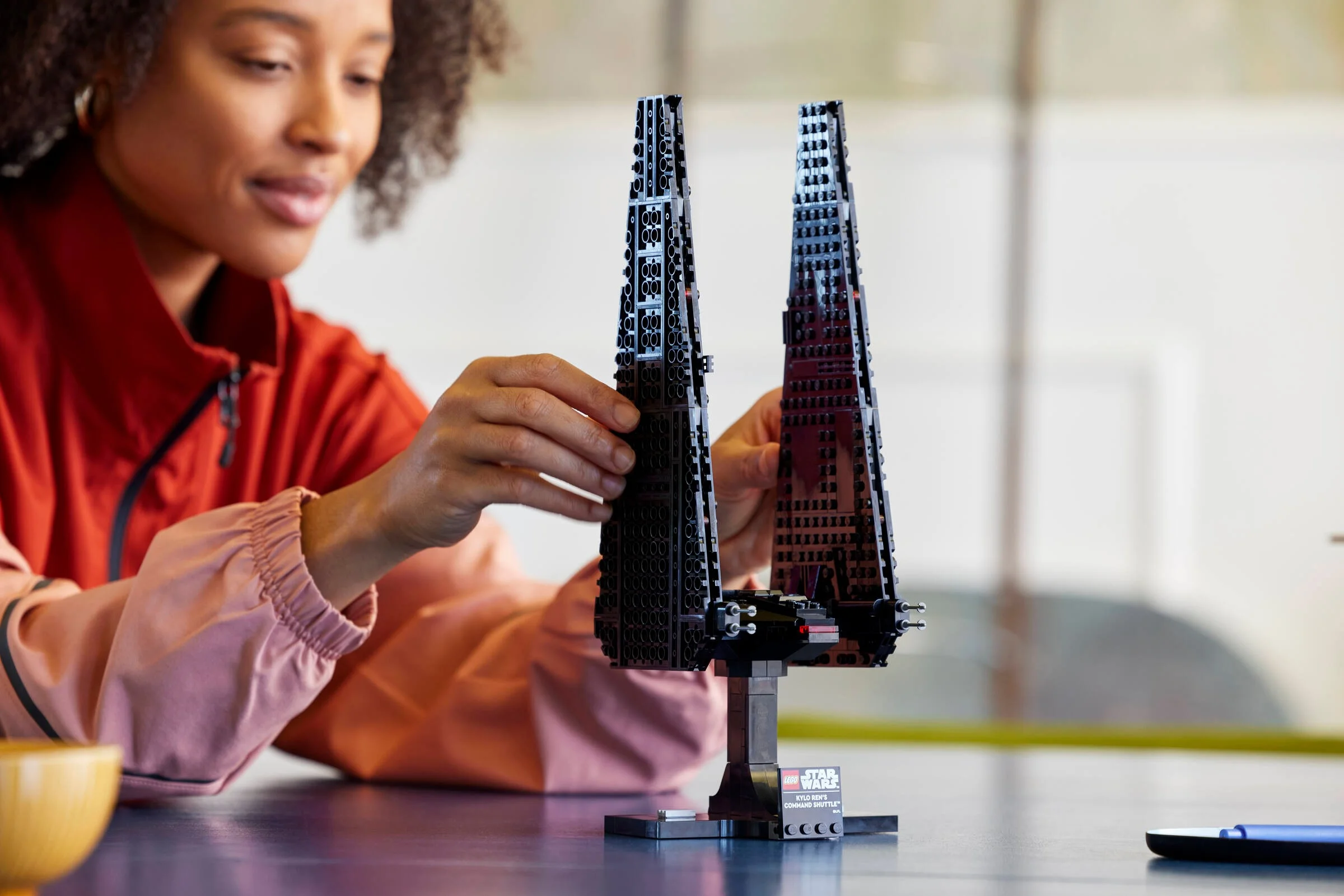O femeie construiește naveta lui Kylo Ren, set LEGO Star Wars 75406.
