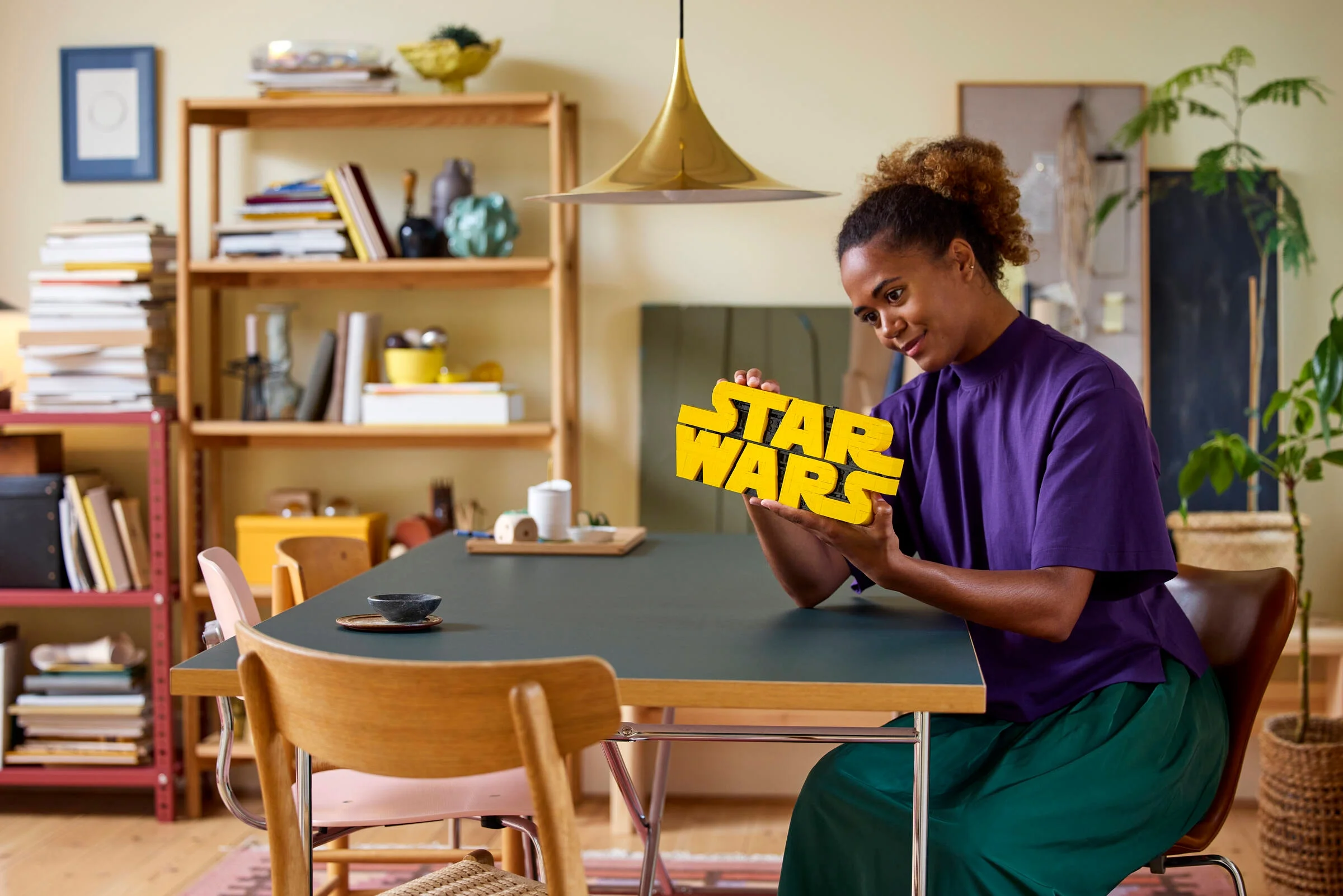 Femeie admirând logo-ul Star Wars construit din cărămizi LEGO.