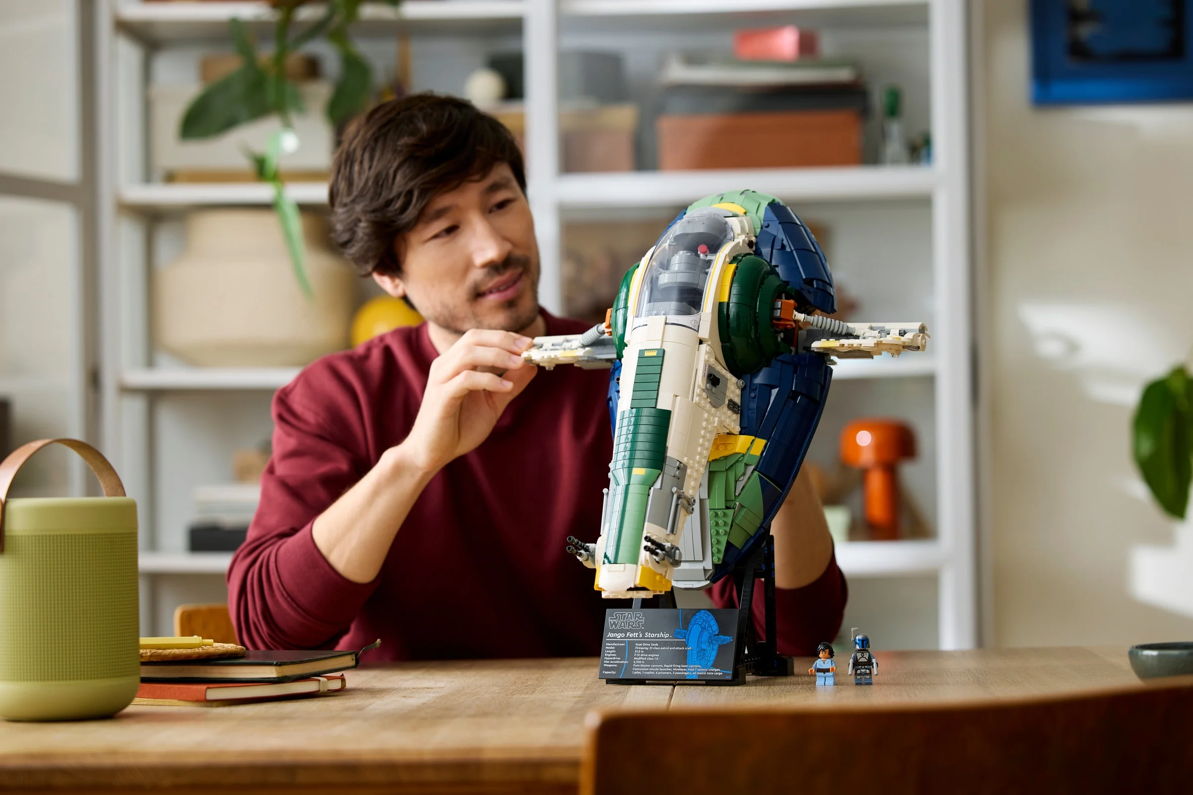 Imagine cu modelul LEGO Jango Fett's Starship, cu un adult interacționând cu aripa navei.