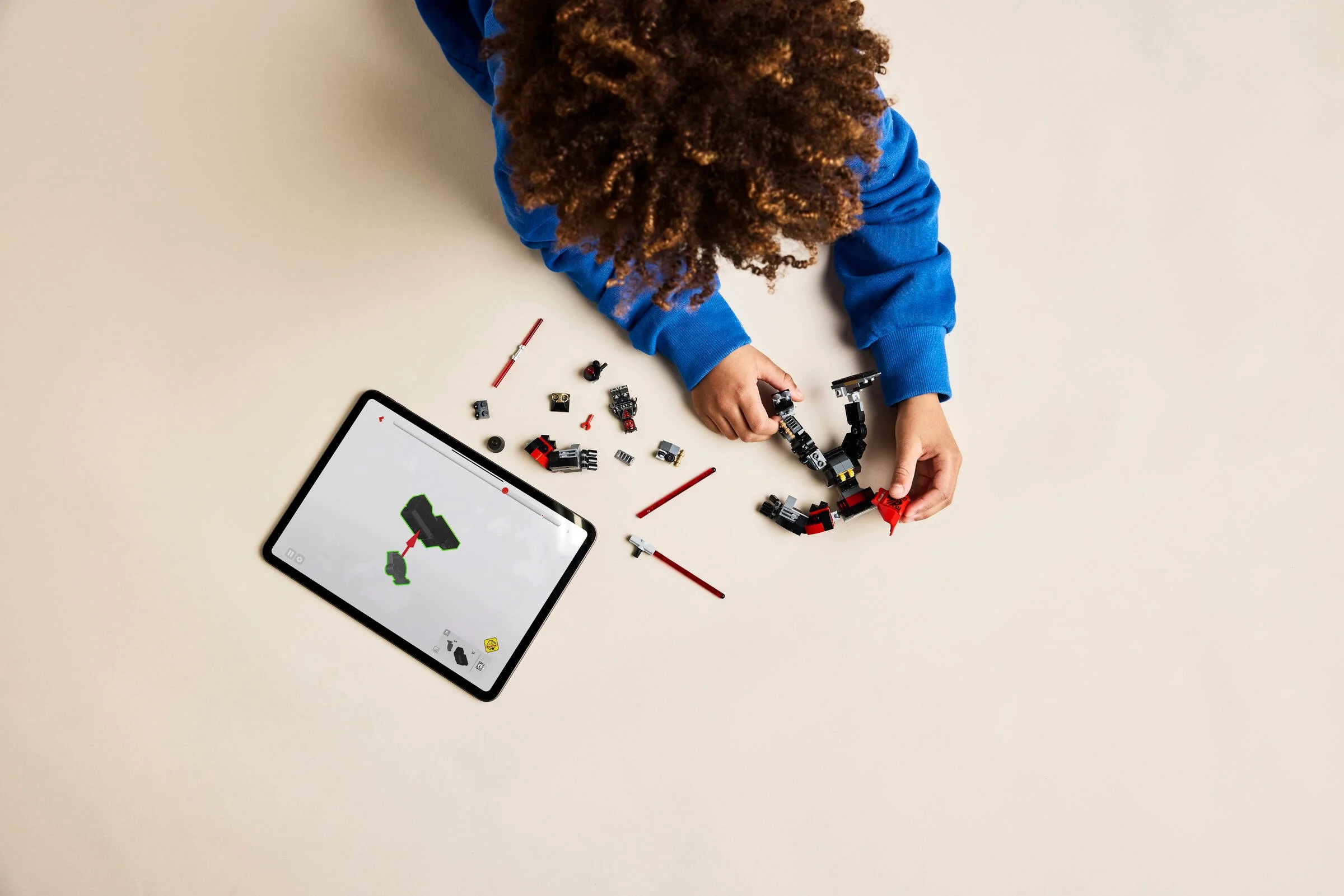 Copil asamblând mech-ul Darth Maul cu instrucțiuni digitale pe tabletă. Construcție LEGO distractivă.