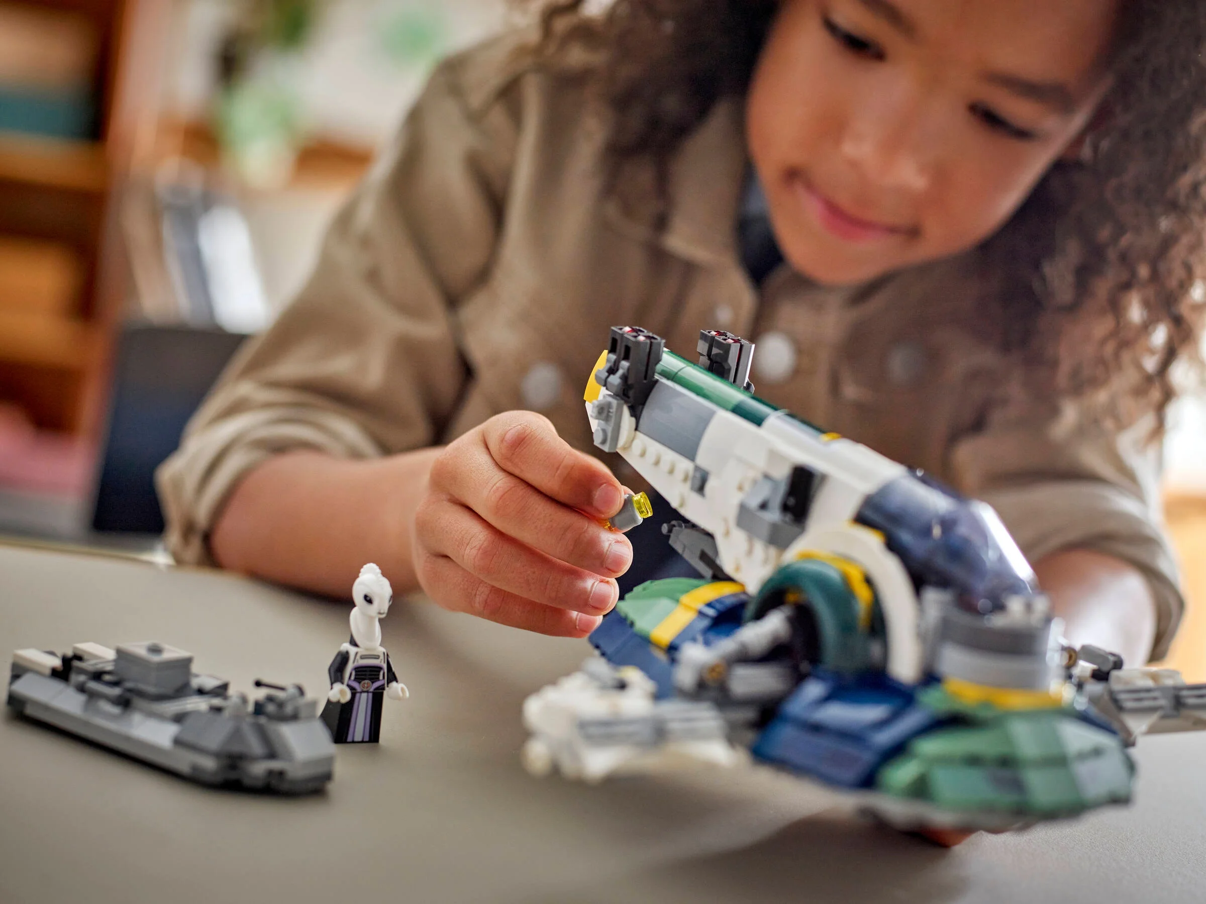 Copil asamblând nava spațială Jango Fett LEGO. Concentrare pe detalii și joacă creativă.
