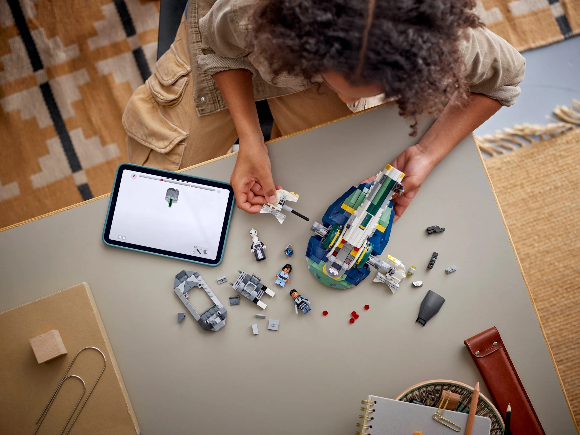 Copil construind nava lui Jango Fett, folosind instrucțiuni digitale. Distracție și creativitate cu LEGO Star Wars.