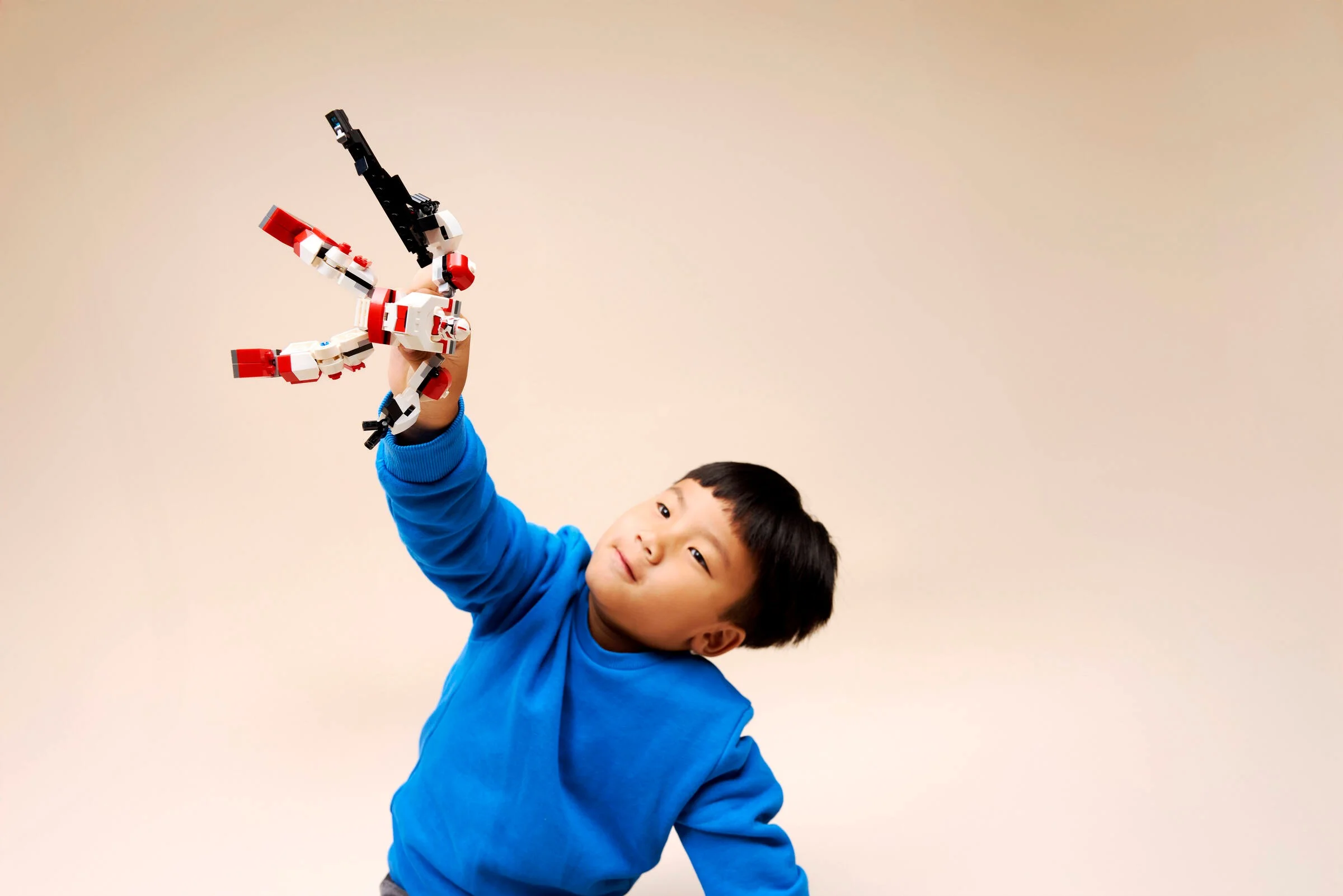 Un băiat se joacă cu robotul Clone Shock Trooper Mech LEGO Star Wars.