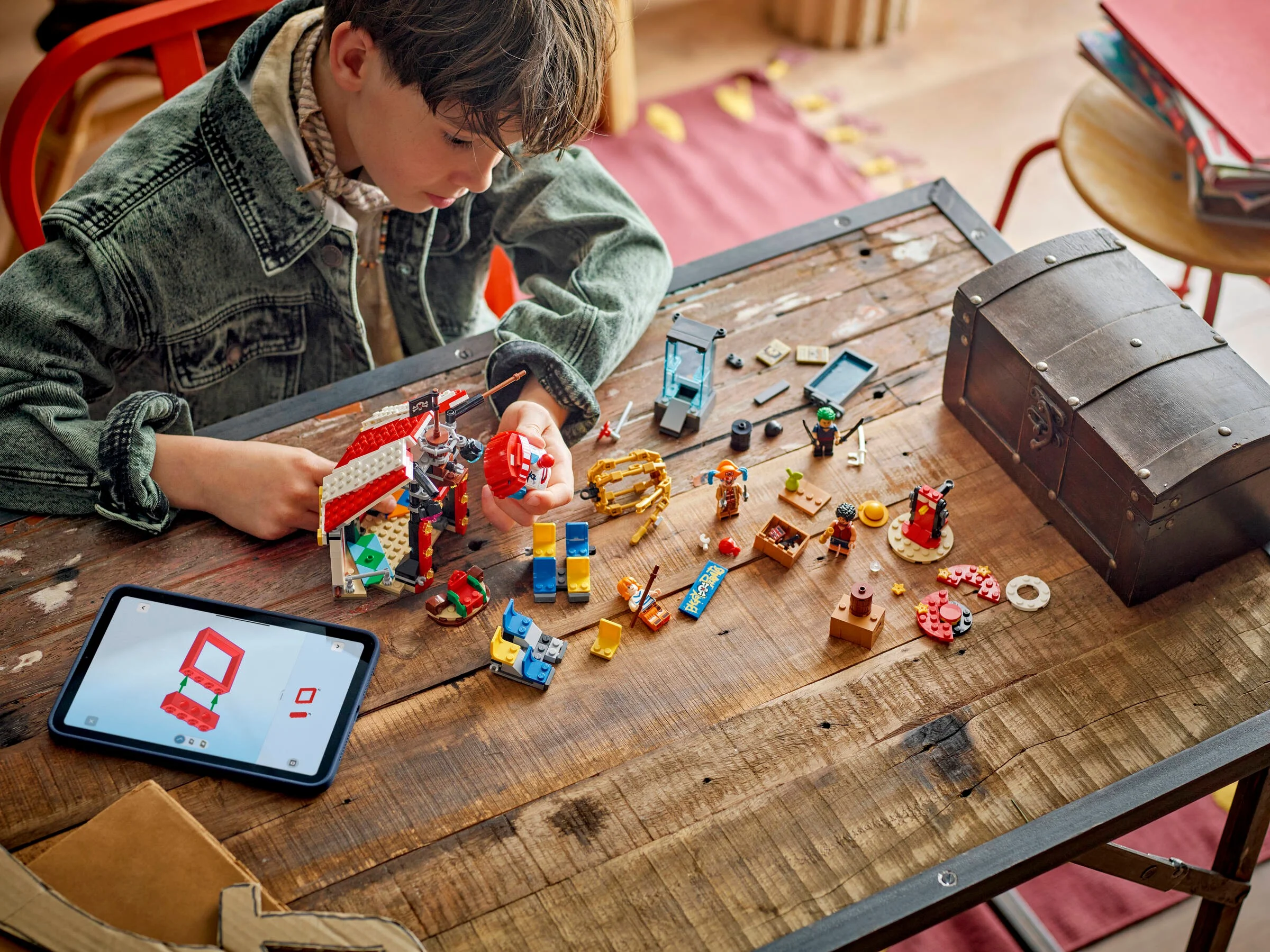 Copil construind setul LEGO Buggy the Clown's Circus Tent, urmând instrucțiunile digitale.