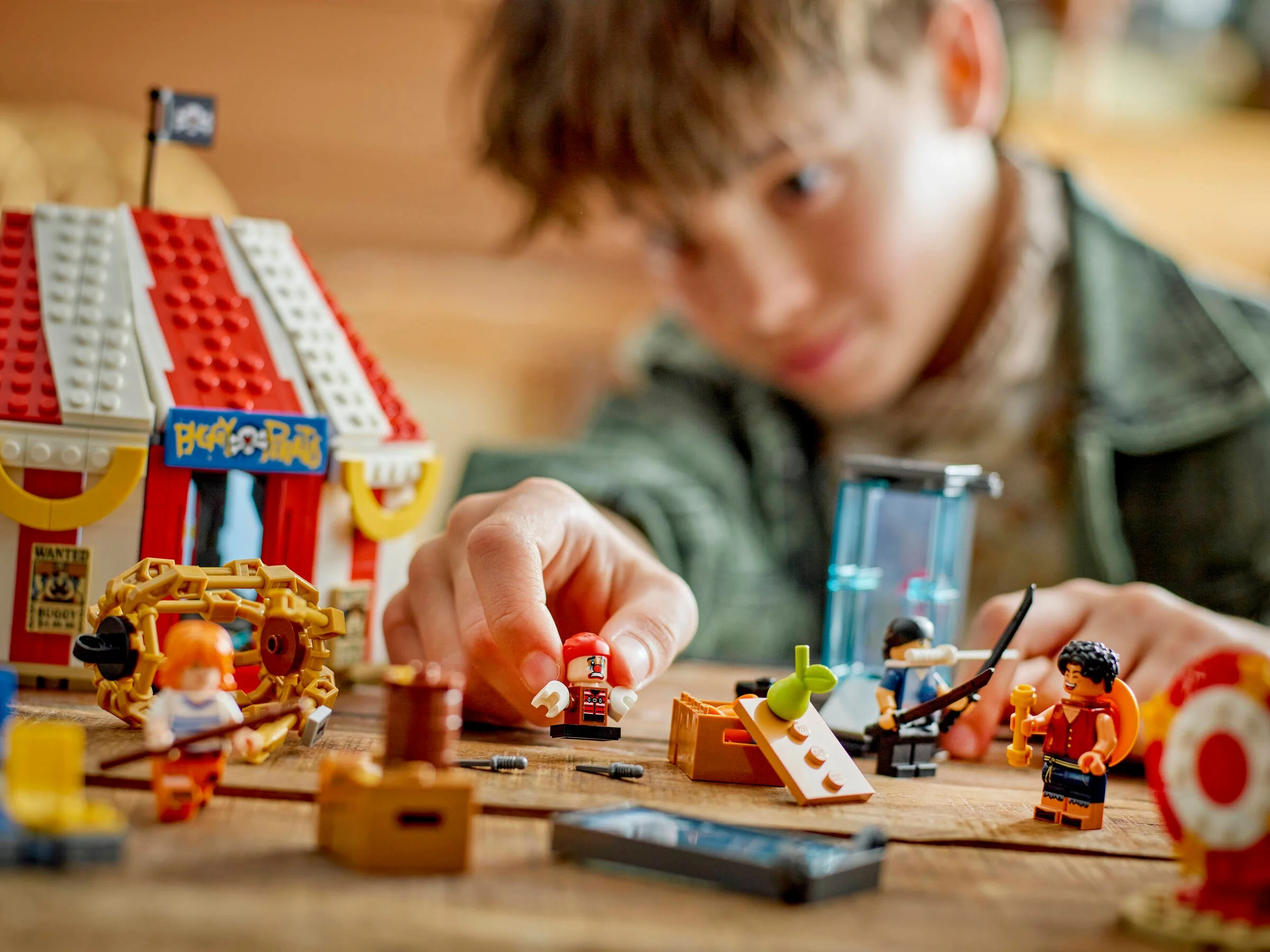 Un copil se joacă cu setul LEGO Cortul de Circ al lui Buggy, cu minifigurine și elemente interactive.