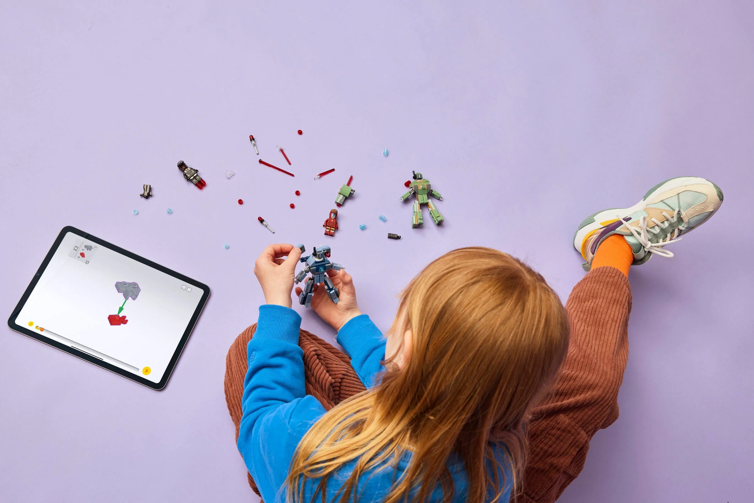 Fetiță construind un drone Hammer LEGO folosind instrucțiuni digitale pe tabletă.