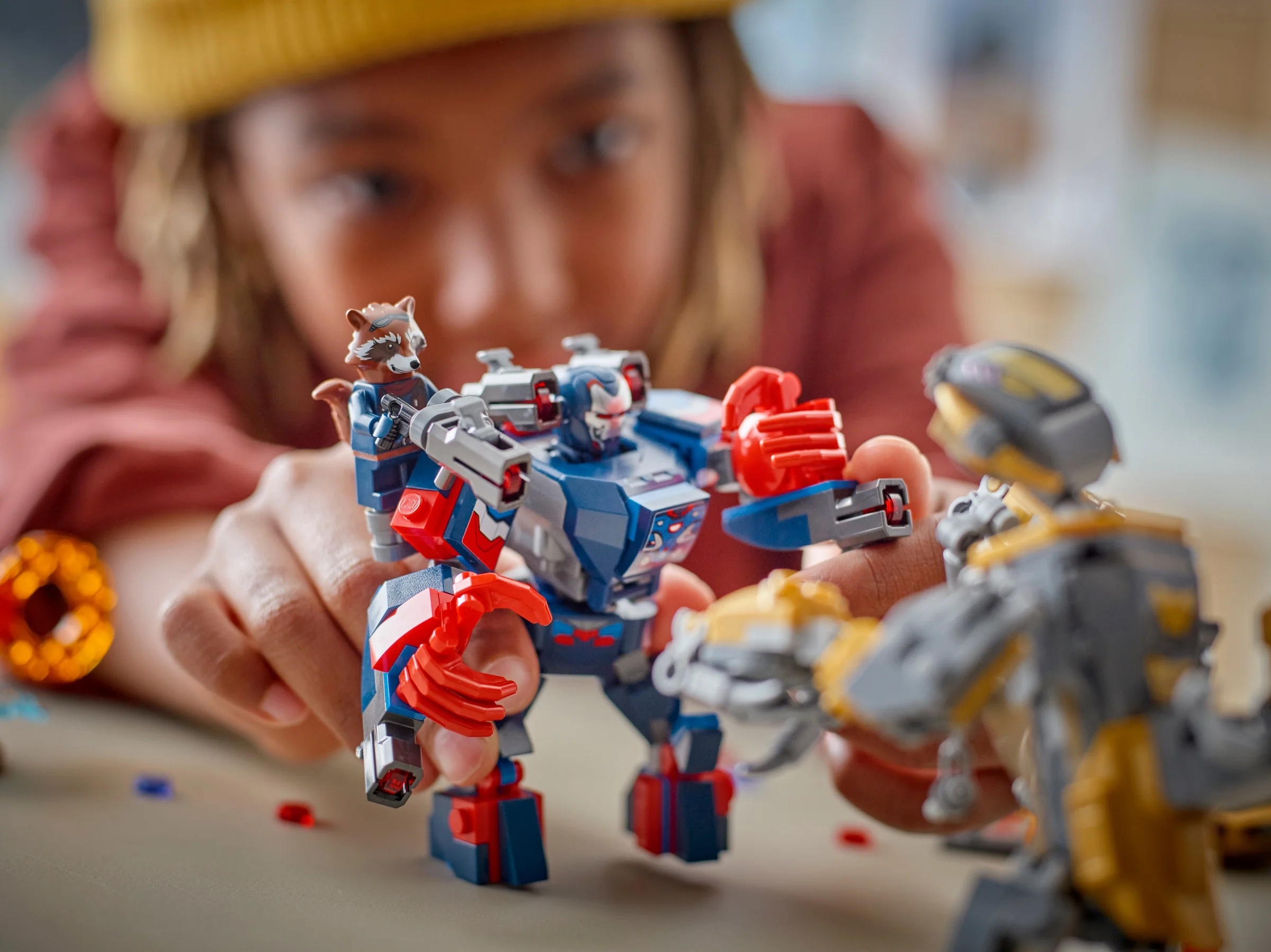 Copil jucându-se cu setul LEGO Thor vs. Chitauri, o scenă distractivă și interactivă.