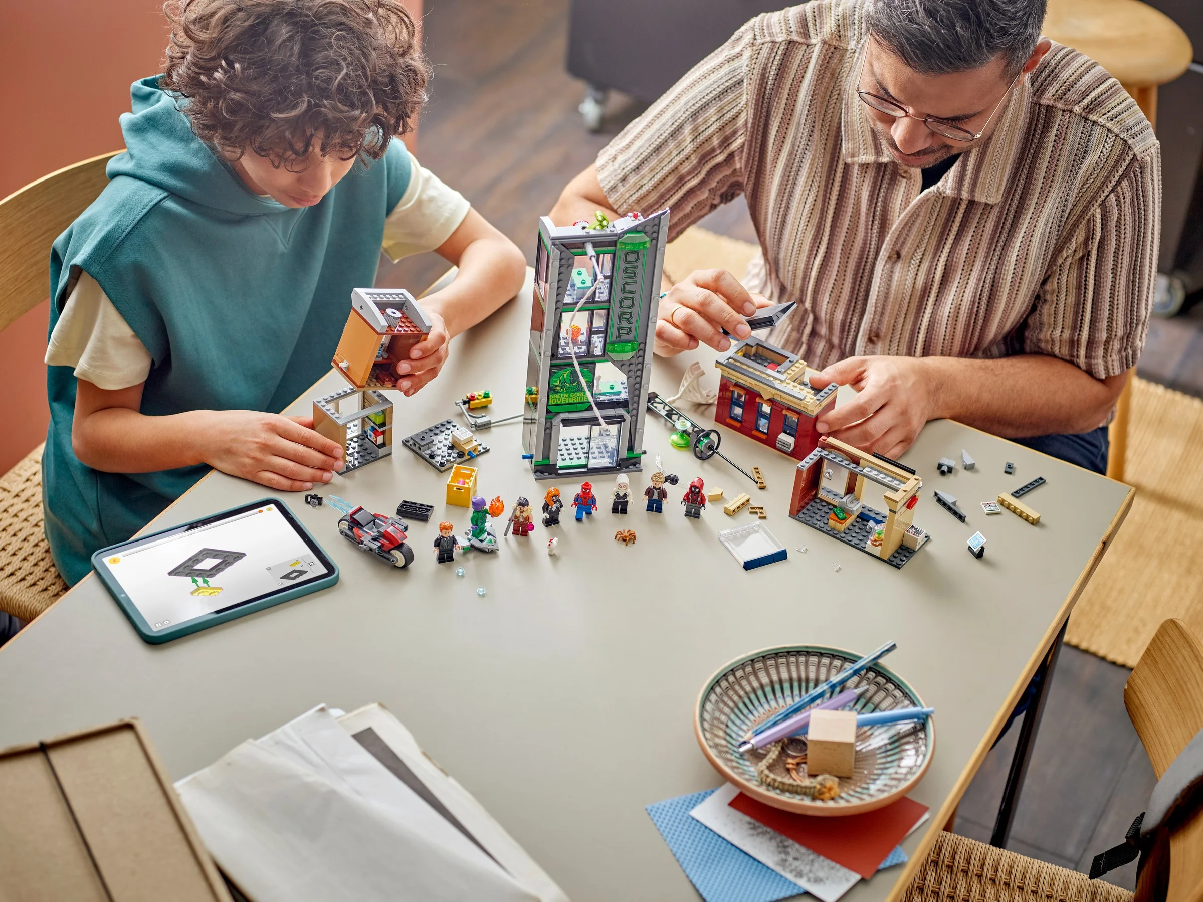 Construind setul LEGO Spider-Man vs. Oscorp, tată și fiu se distrează împreună. Scene interactive și minifigurine.
