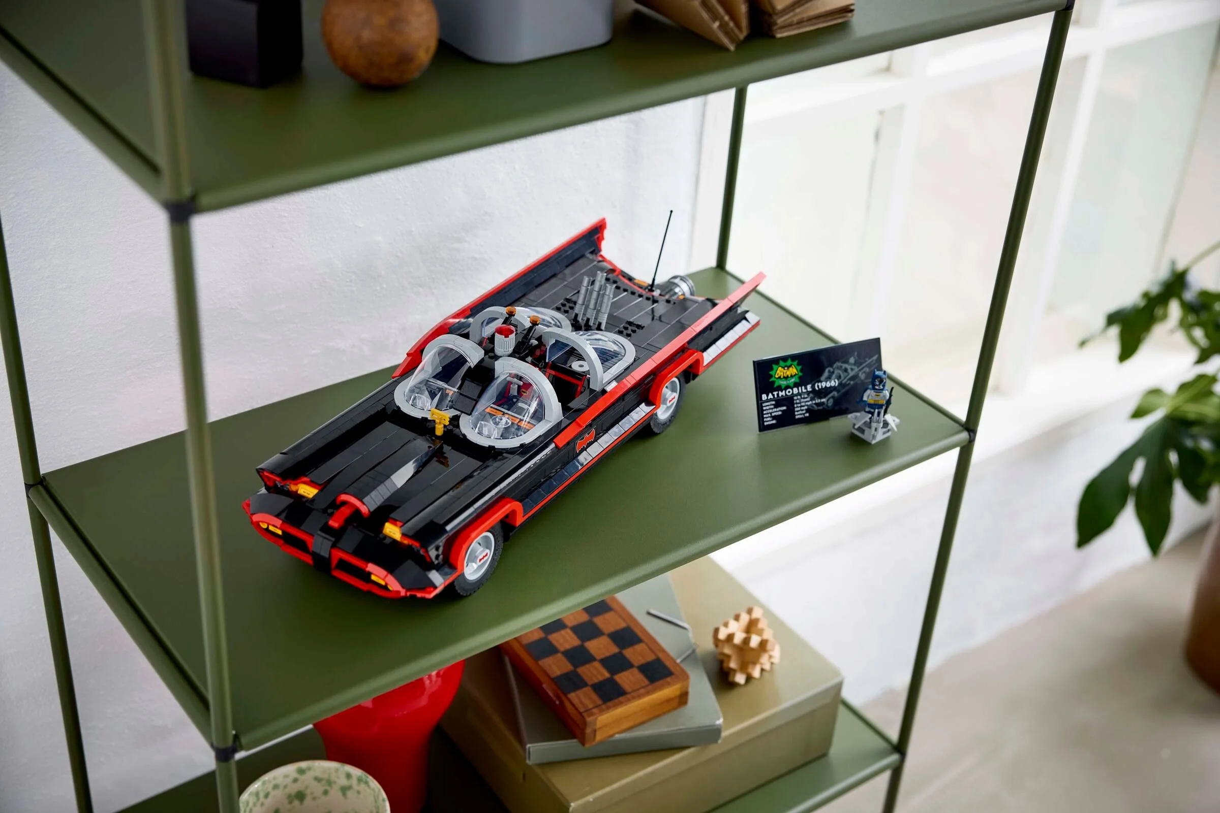 Imagine cu Batmobile-ul LEGO din seria TV clasică pe un raft, cu un stativ cu specificații.