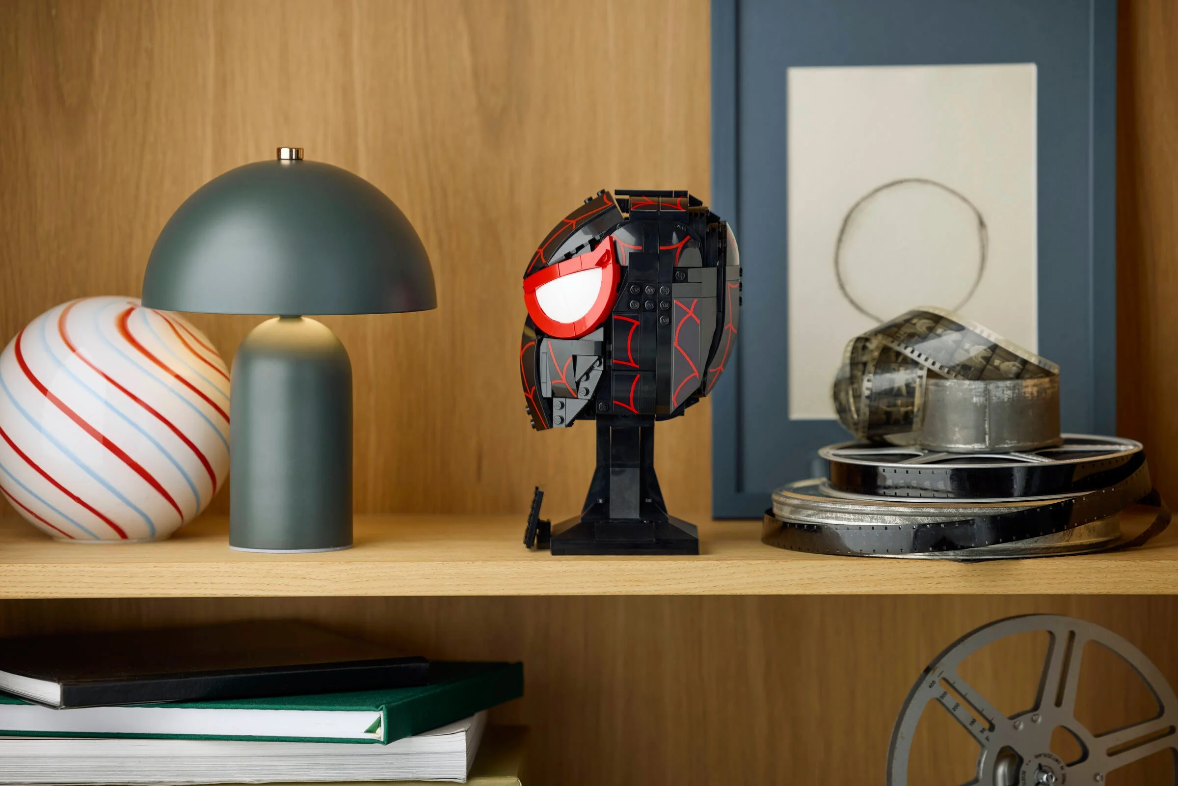 Masca lui Miles Morales din LEGO, un decor atrăgător pe raftul din lemn.