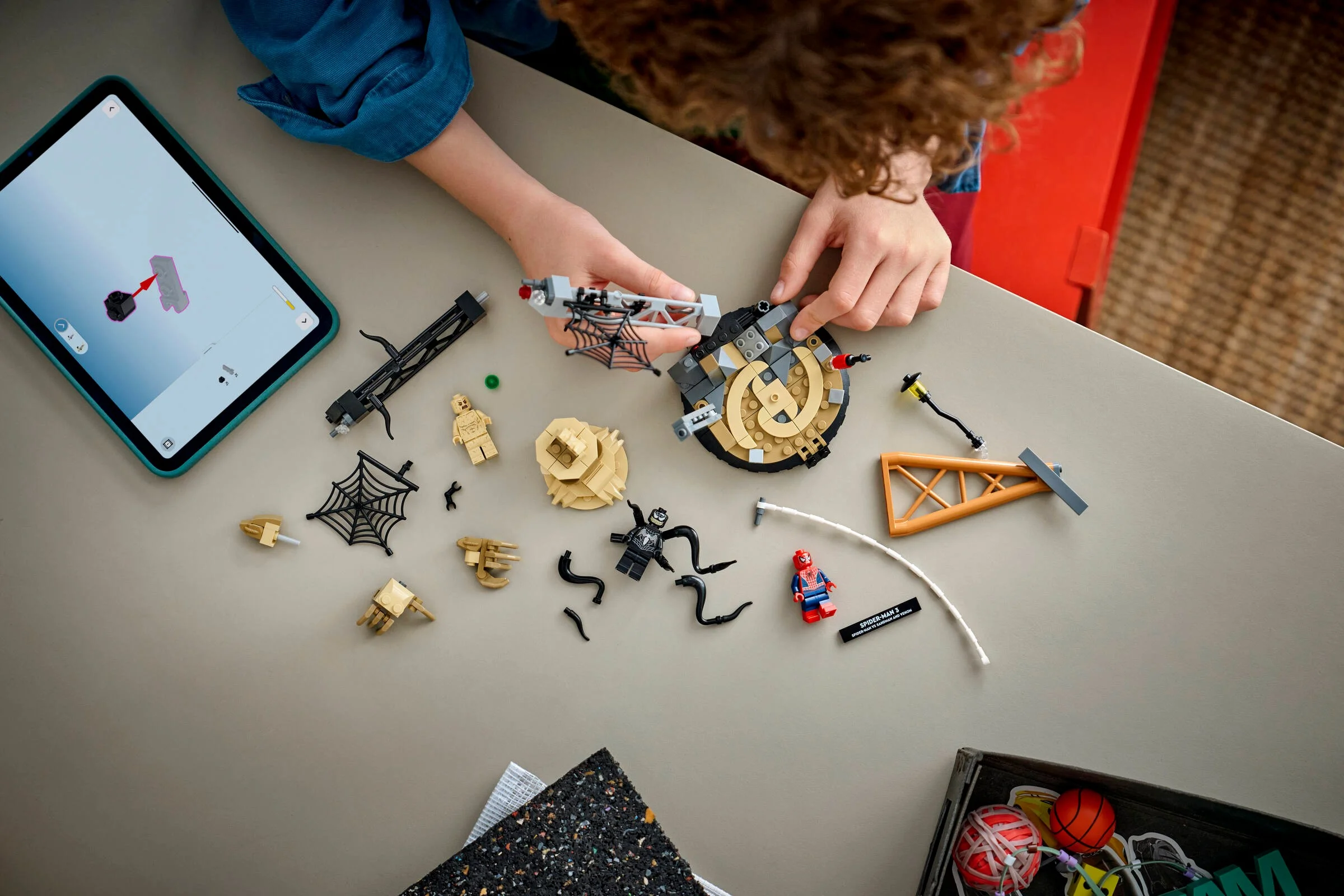 Copil construind setul LEGO Epic Battle Spider-Man vs. Sandman cu instrucțiuni digitale.