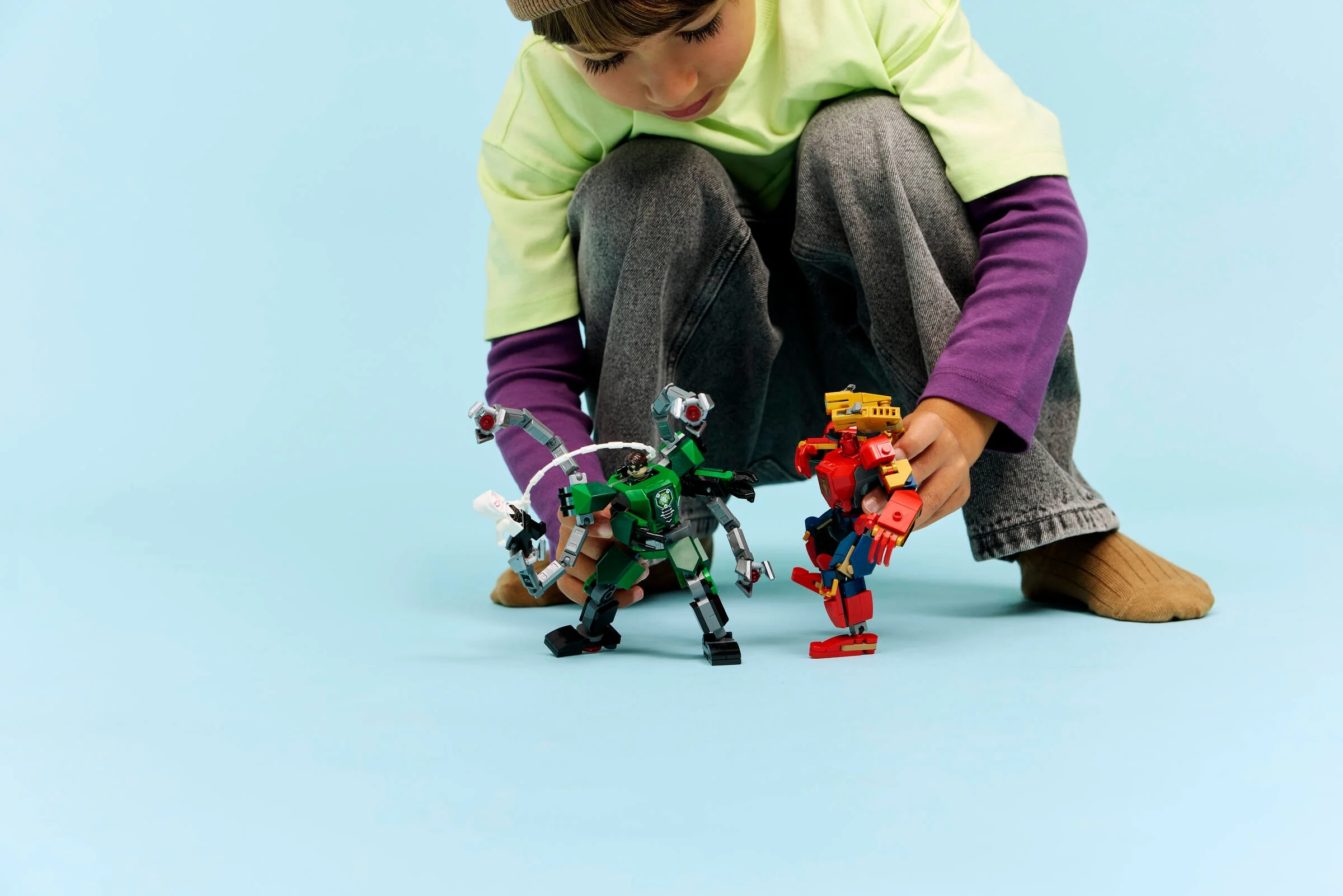 Un copil se joacă cu setul LEGO Mech Battle: Spider-Man vs. Doc Ock.