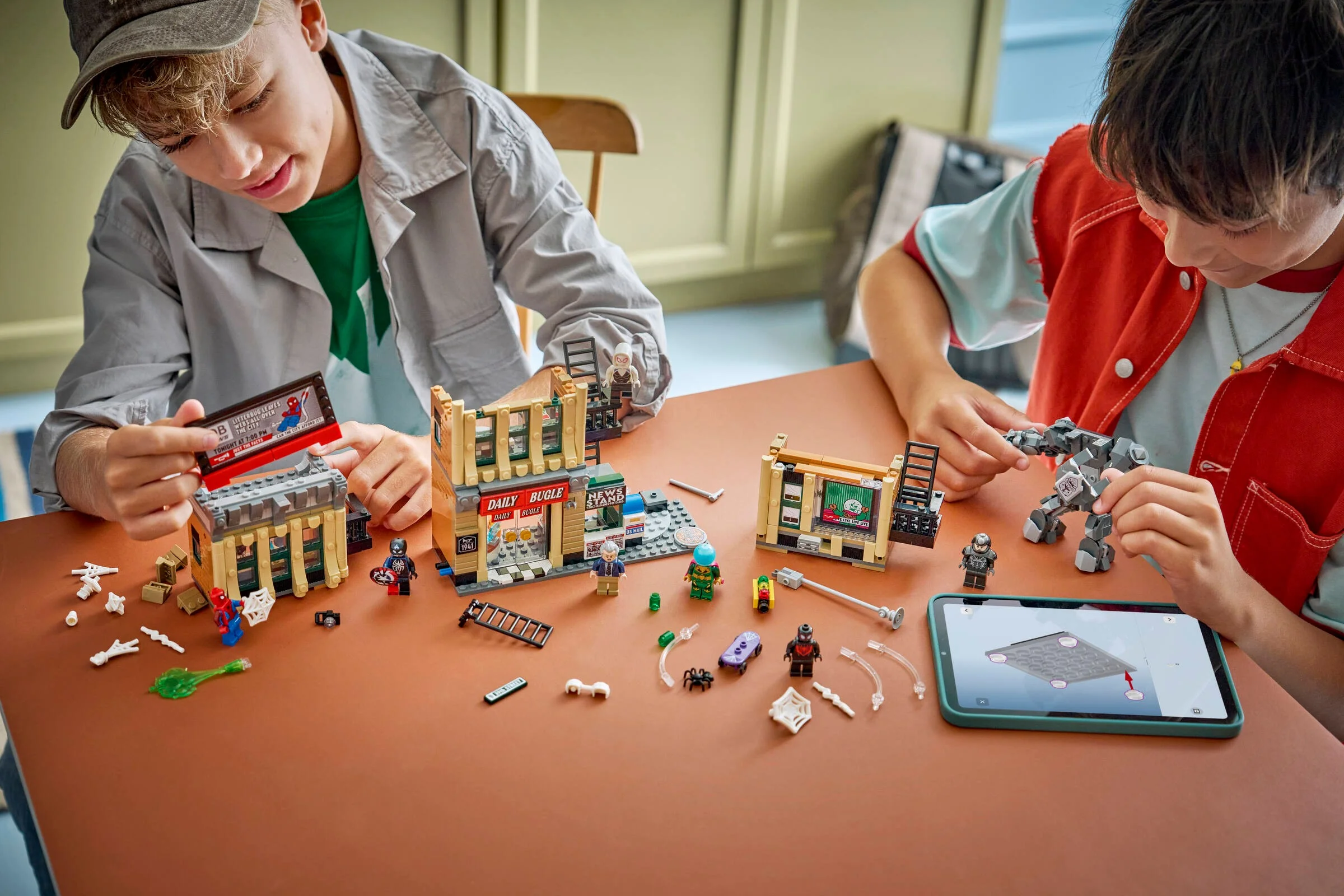 Copii asamblează setul LEGO Spider-Man vs. Mysterio: Daily Bugle, pe o masă. 