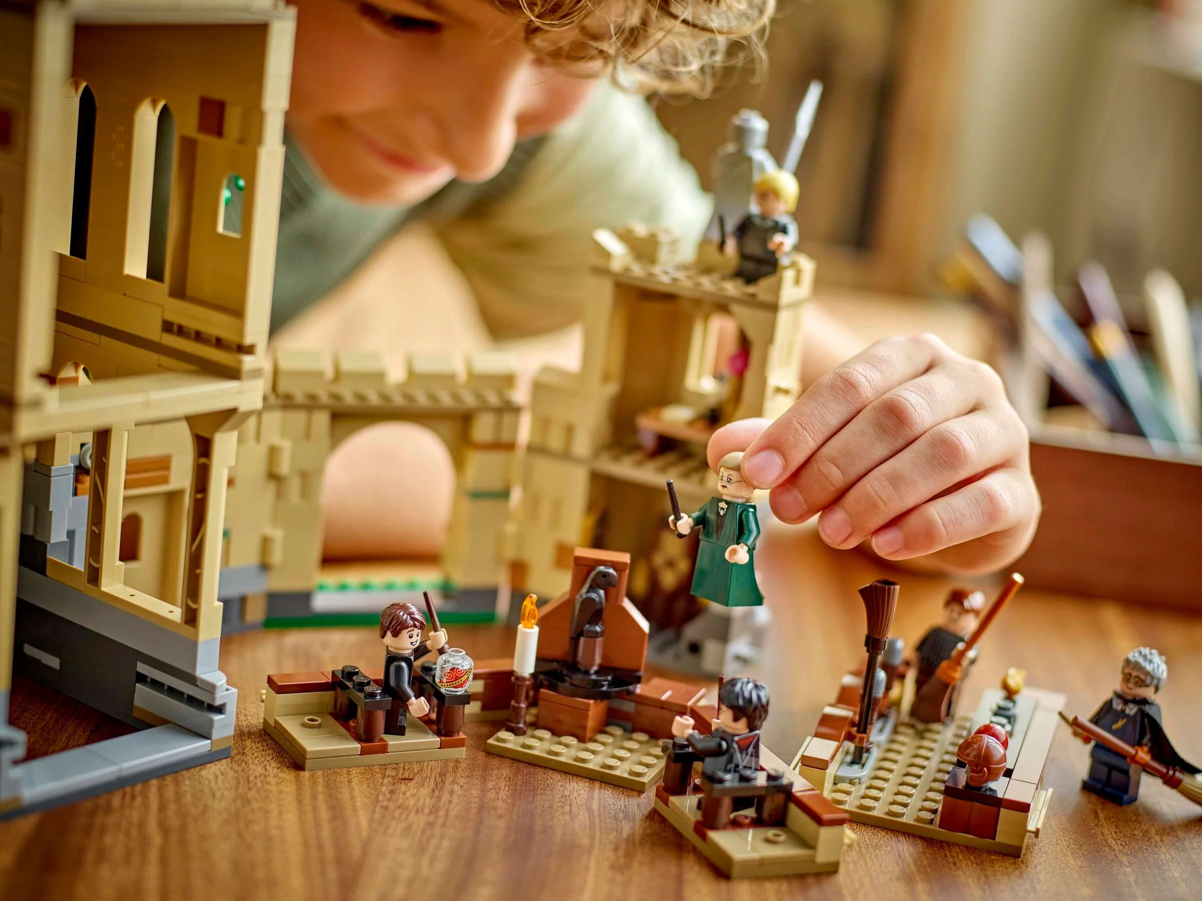 Un copil se joacă cu setul LEGO Hogwarts, lecții de zbor. Scene detaliate și minifigurine.