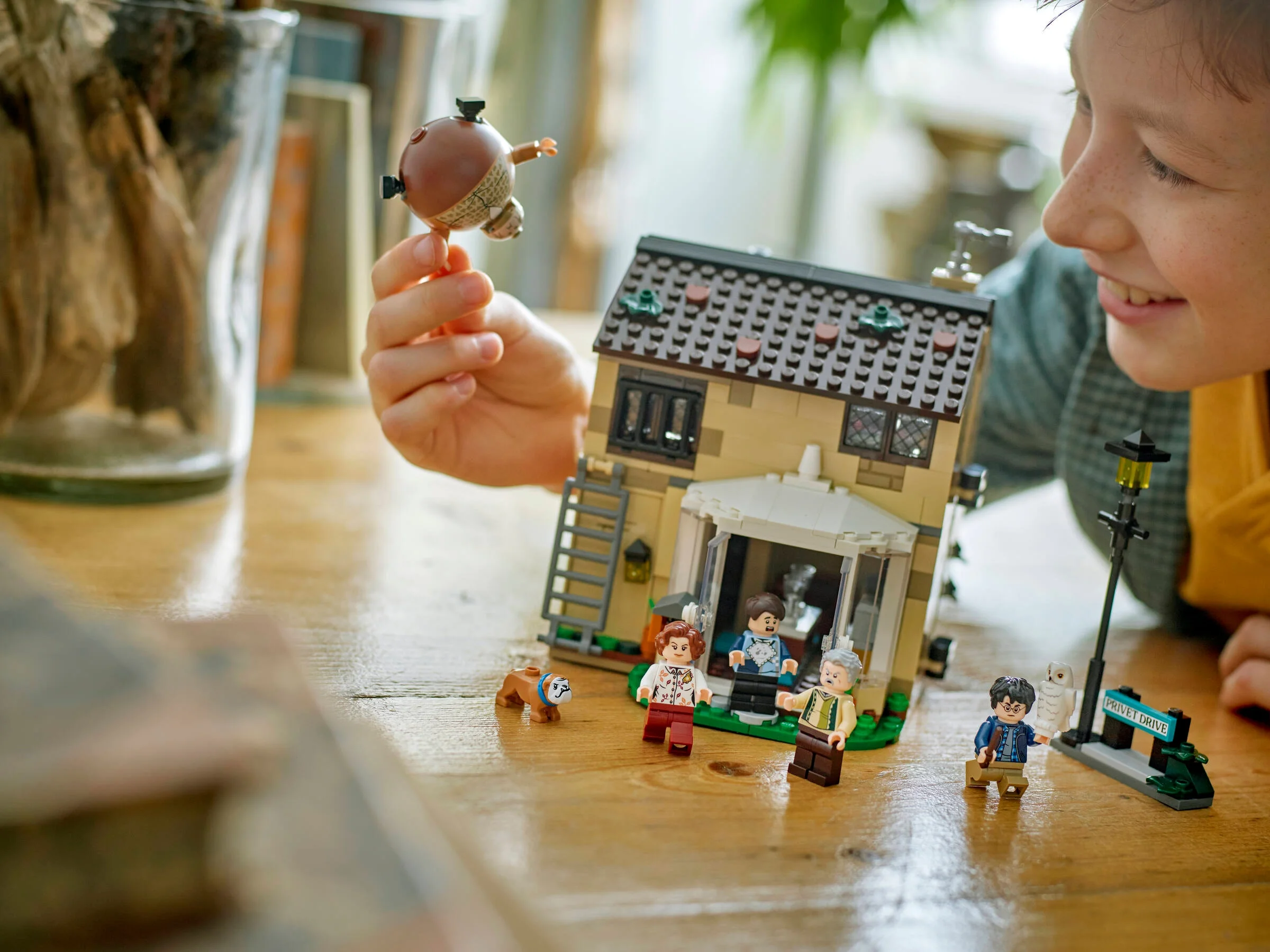 Copil se joacă cu setul LEGO Privet Drive, incluzând mătușa Marge transformată în balon.