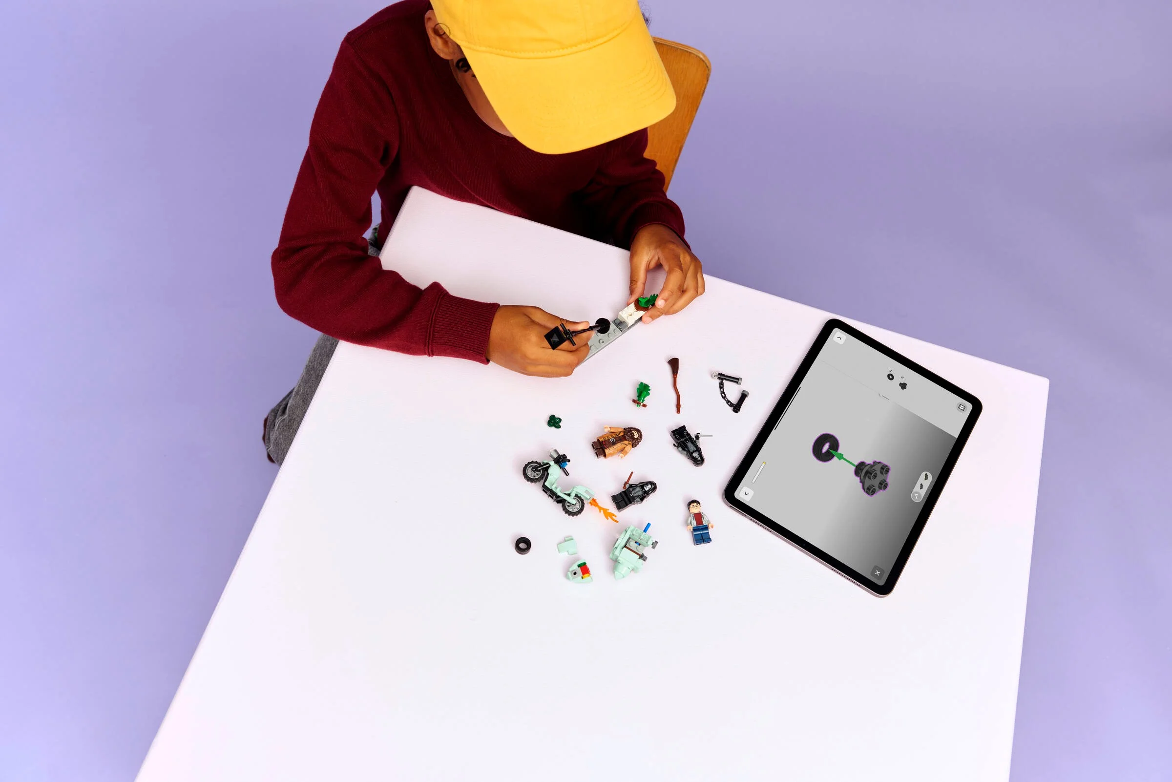 Copil asamblând setul LEGO Hagrid și Harry cu instrucțiuni pe tabletă. Distracție magică!