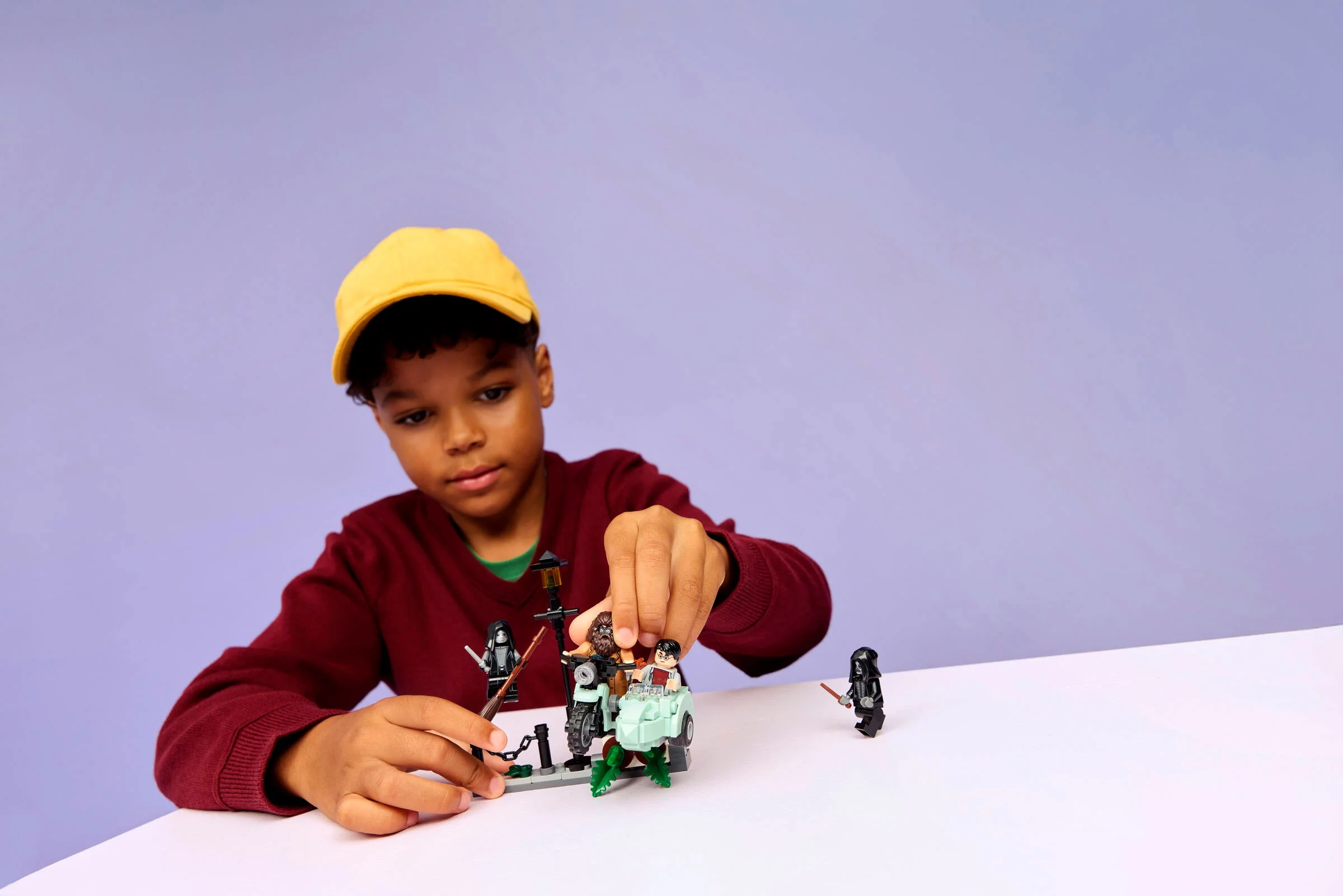 Copil se joacă cu setul LEGO Hagrid & Harry's Privet Drive Escape. Distracție garantată!