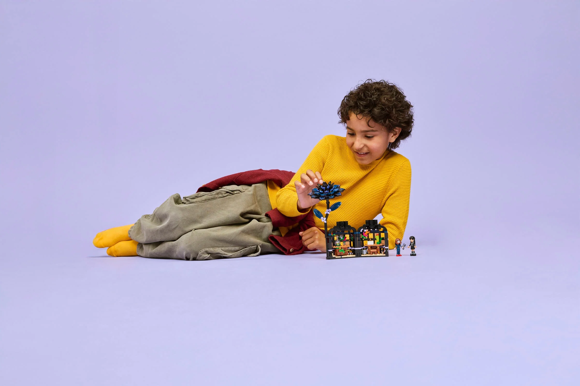 Copil admirând setul LEGO Black Dahlia Flower. Distracție și creativitate cu LEGO!