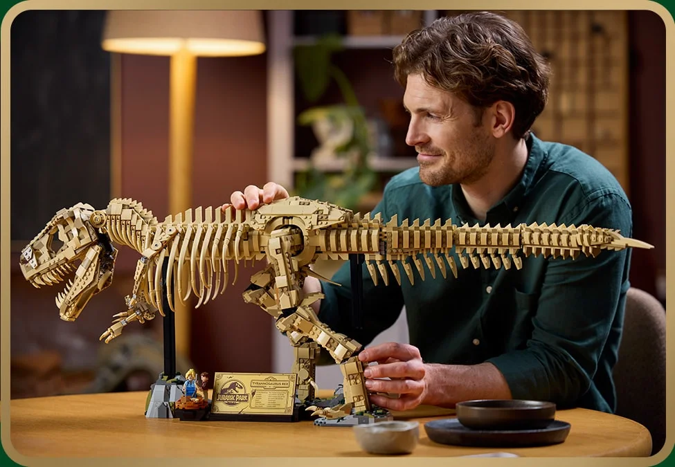 Bărbat admirând fosila T-Rex LEGO 76968, o experiență Jurassic World captivantă.