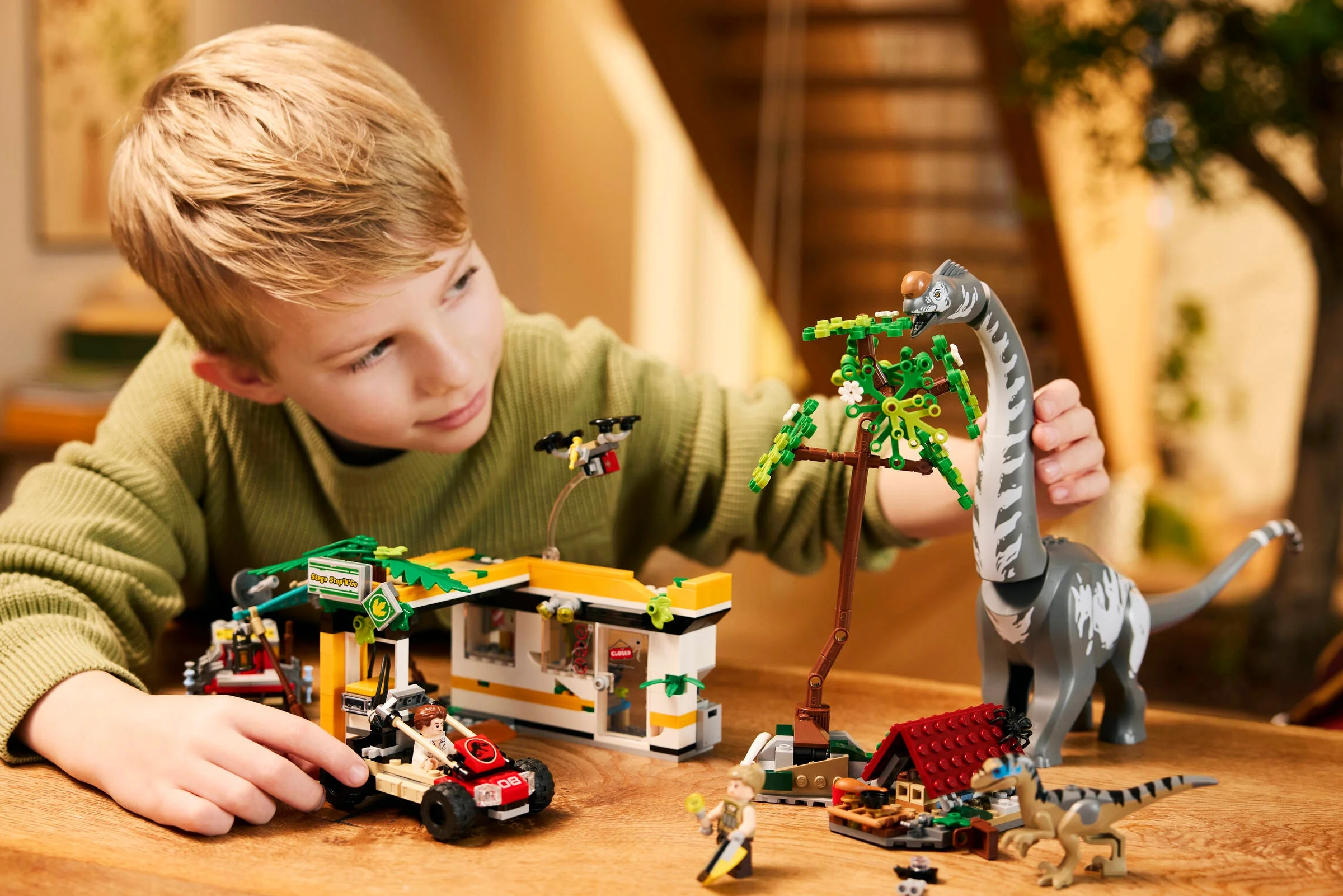 Copil se joacă cu setul LEGO Jurassic World 76973, explorând aventurile cu dinozauri.