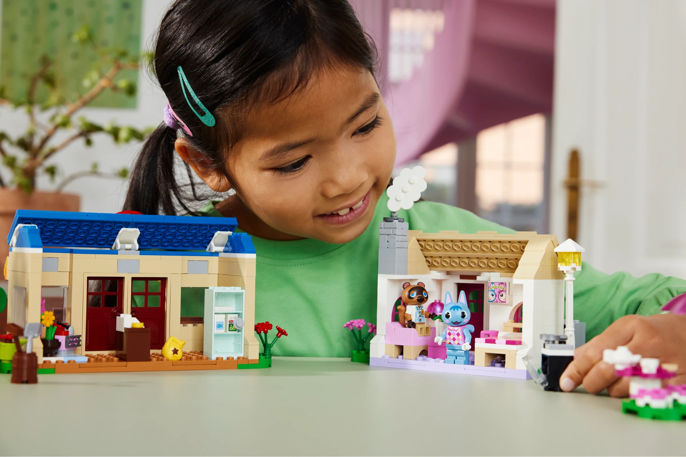 Copil construind setul LEGO Animal Crossing 77050, cu Nook's Cranny și casa lui Rosie.