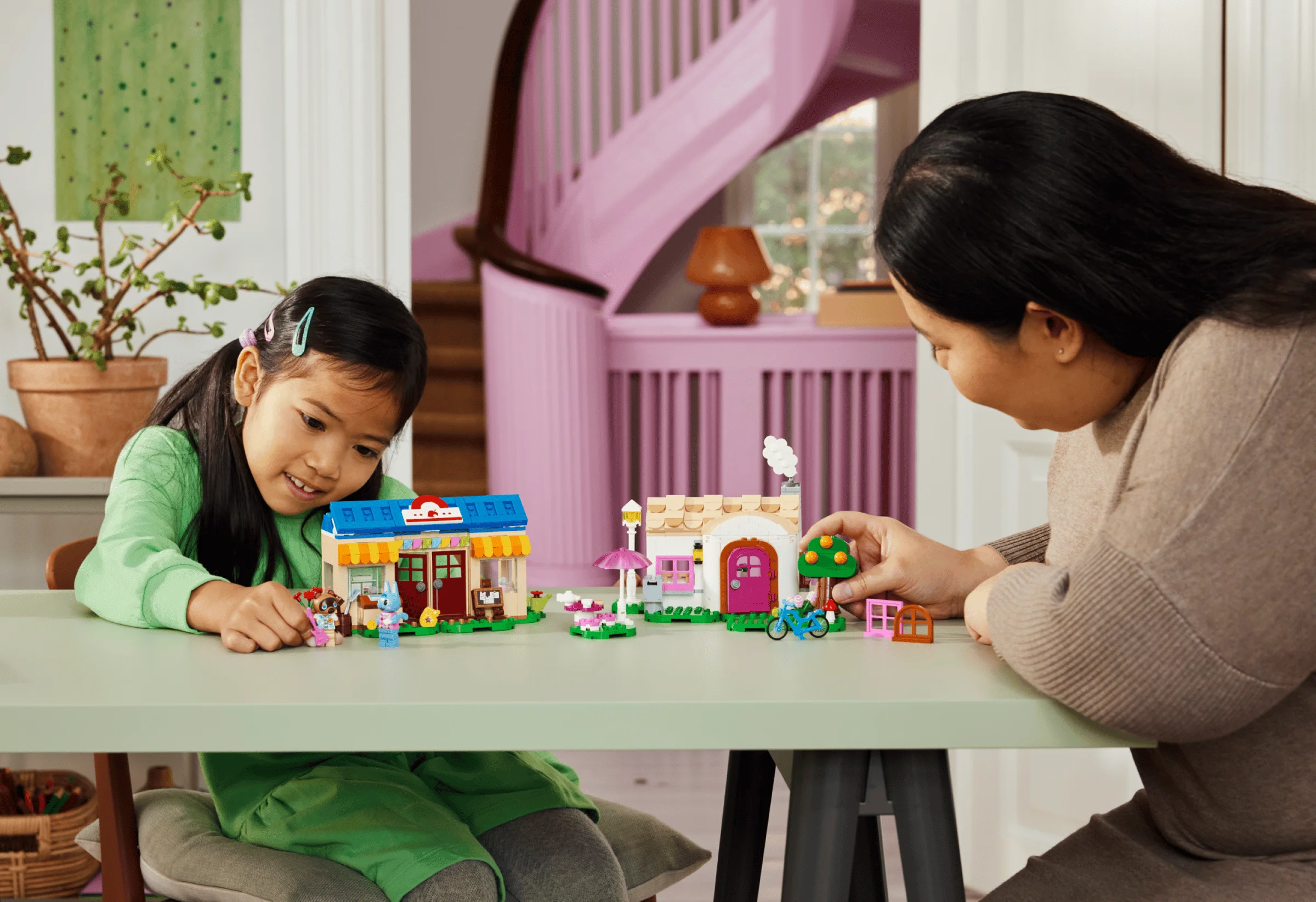 O fetiță și o femeie se joacă cu setul LEGO Animal Crossing Nook's Cranny și Rosie's House.
