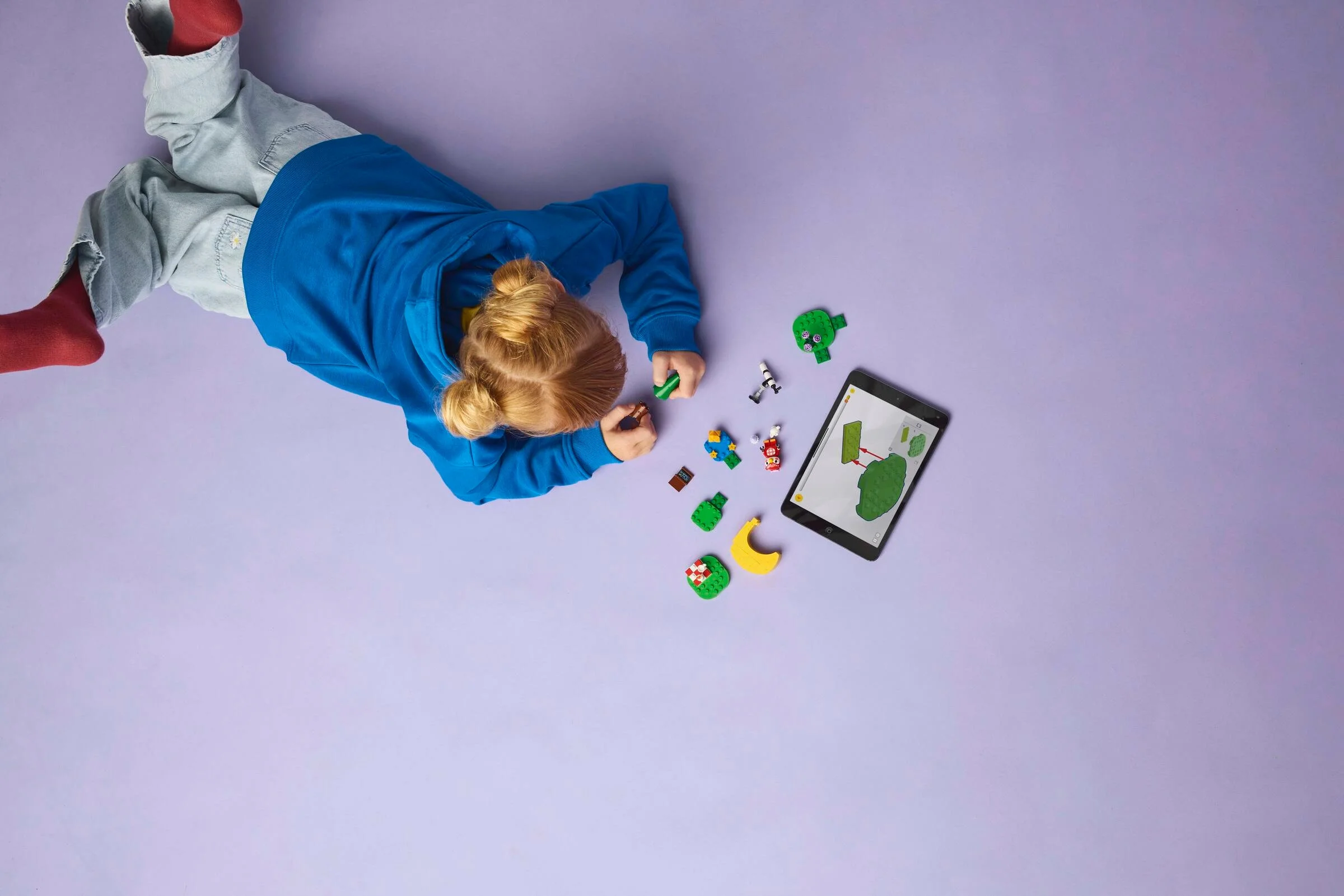 Copil construind setul LEGO Stargazing with Celeste, folosind instrucțiuni digitale.