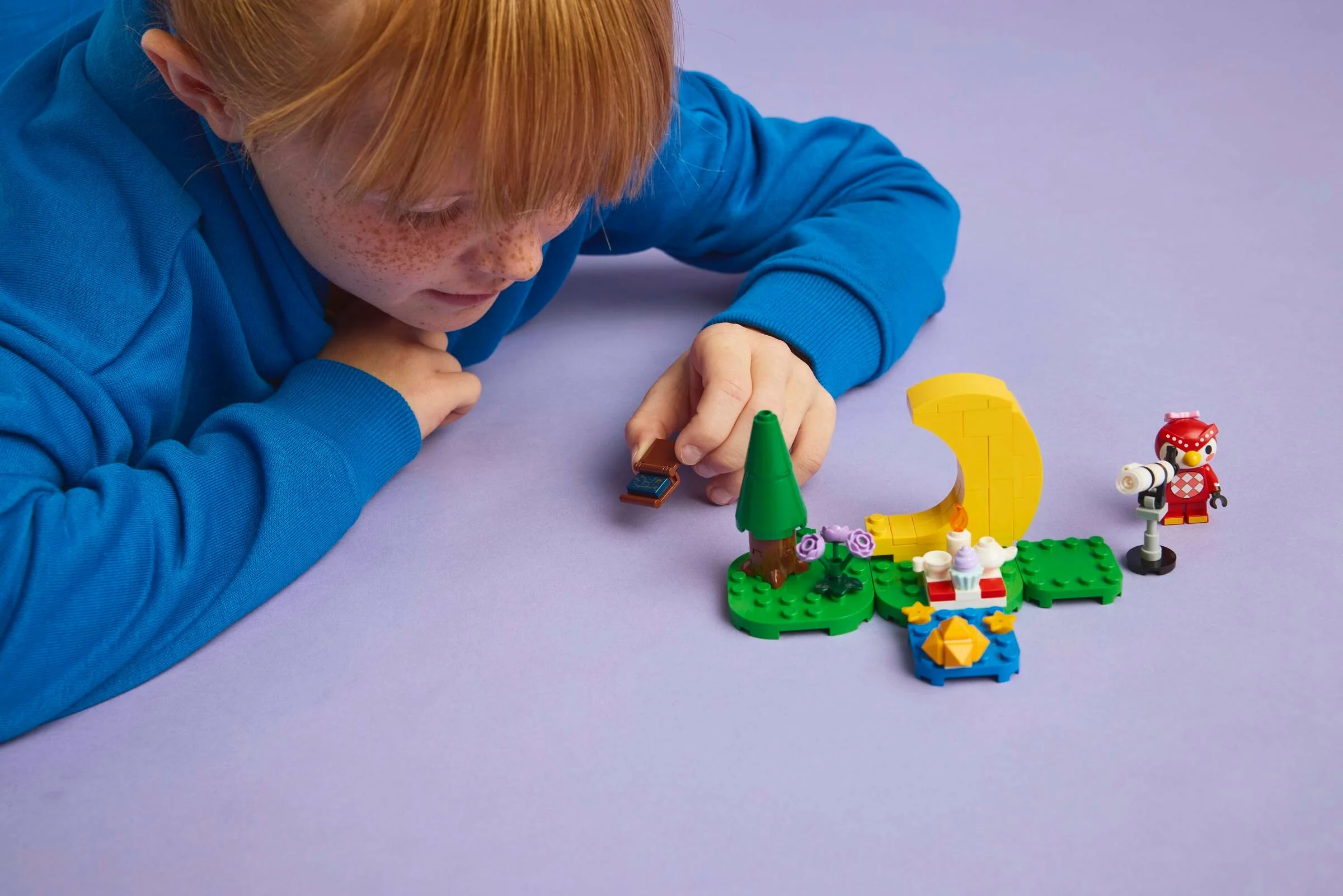 Copil interacționând cu setul LEGO Animal Crossing. Elemente colorate și distractive.