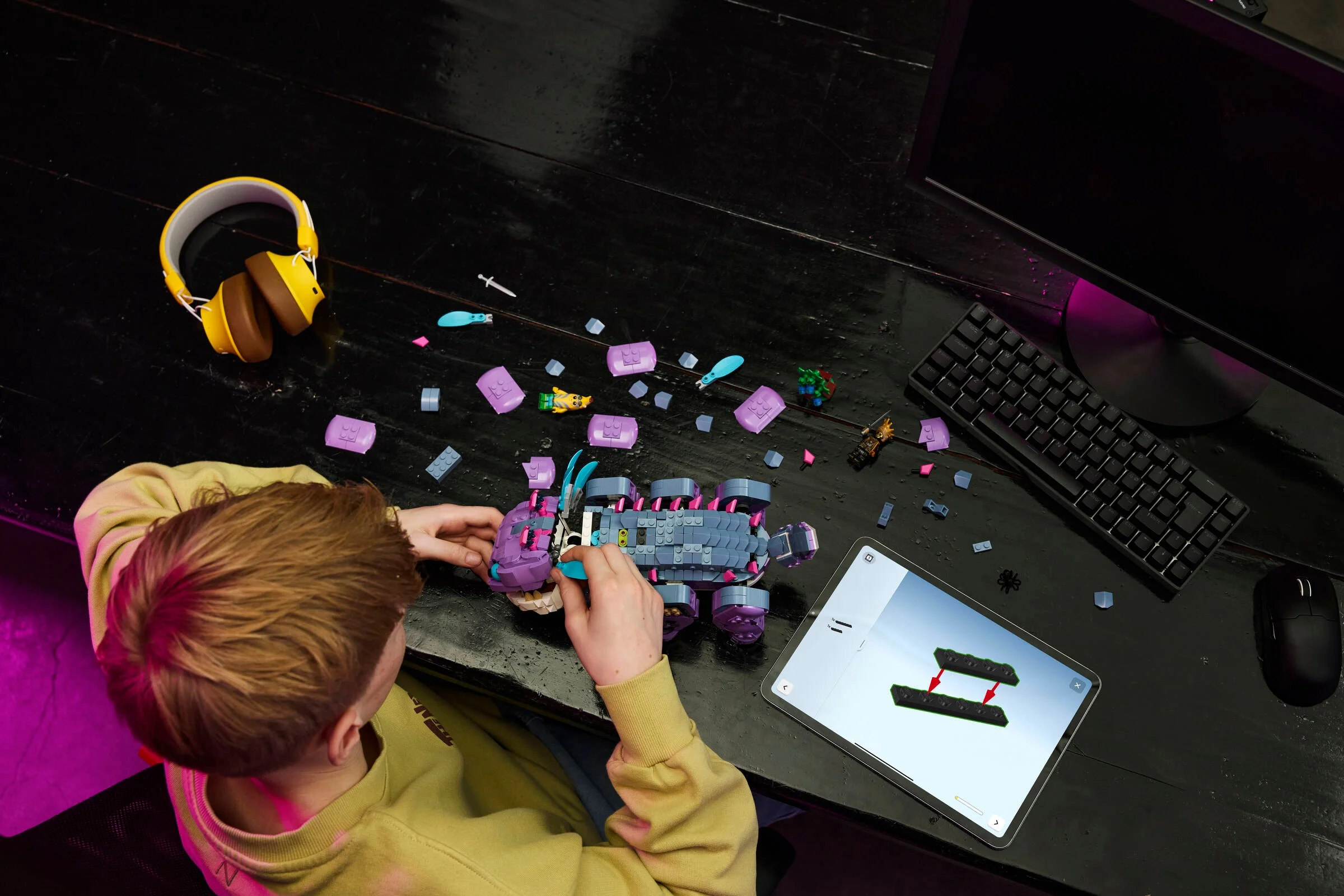 Copil construind Klombo LEGO. Instrucțiunile sunt pe tabletă. Distracție garantată!