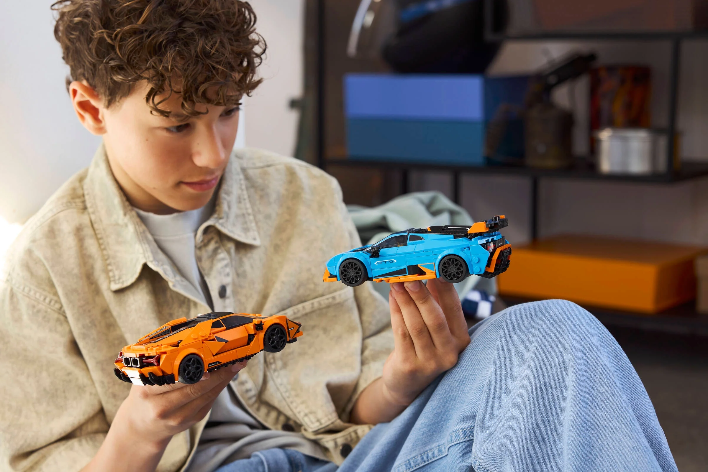 Băiat admirând modelele LEGO Lamborghini Revuelto și Huracán STO, jucându-se cu ele.