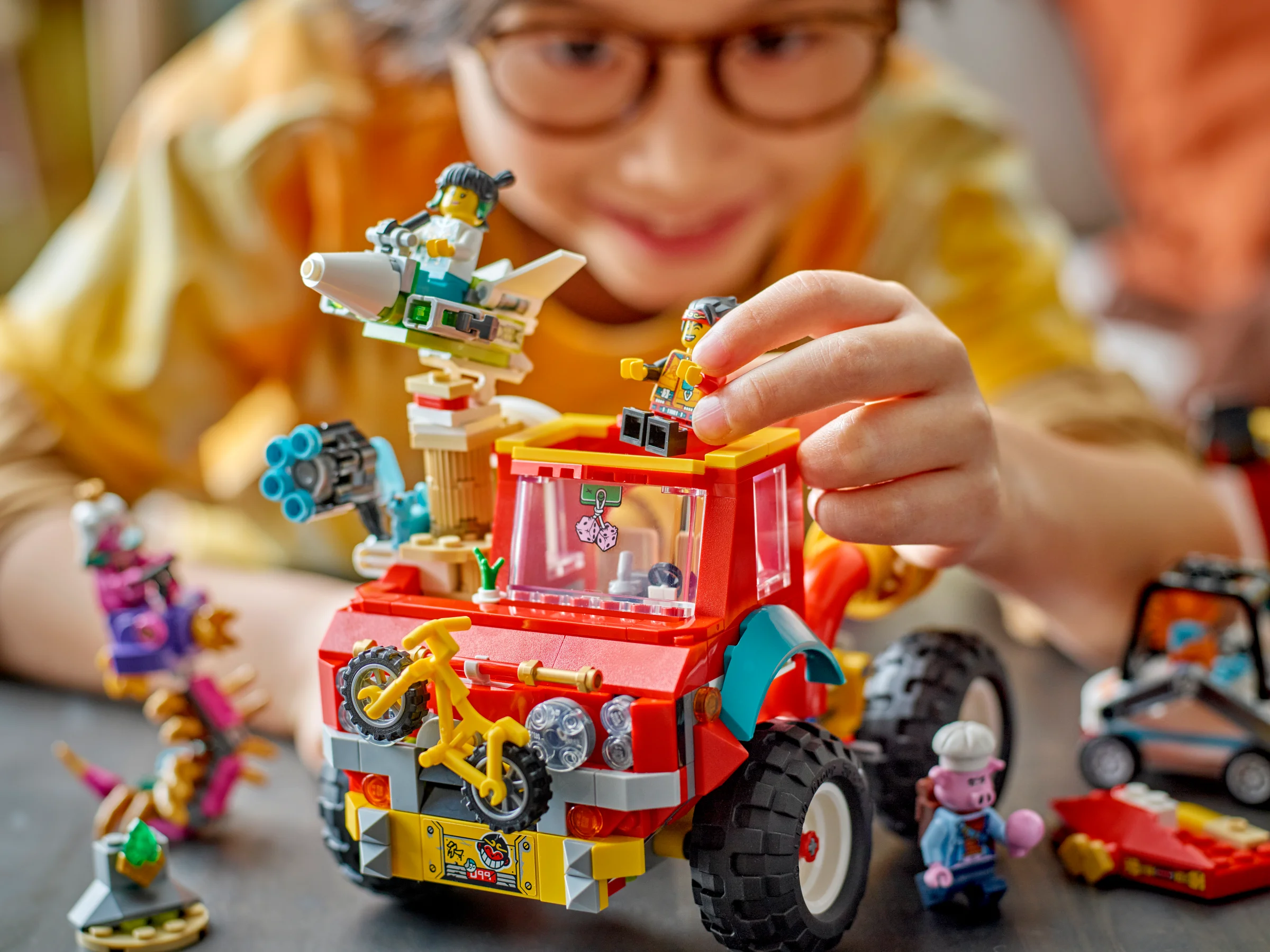 Copil jucându-se cu camionul Monkie Kid și minifigurinele LEGO. Distracție garantată!