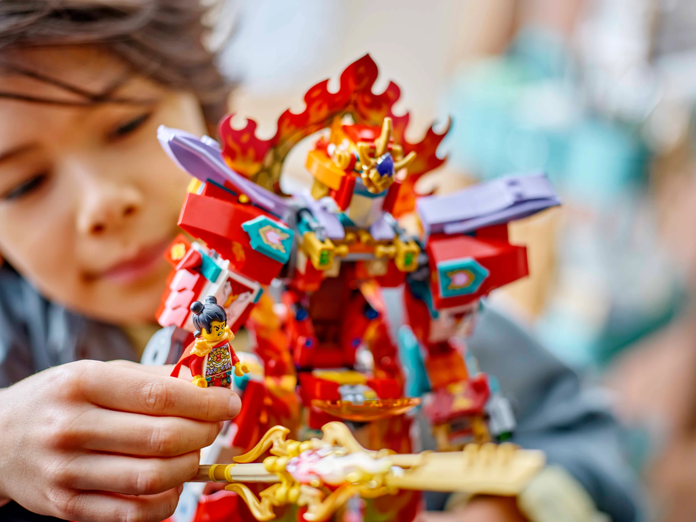 Copil se joacă cu setul LEGO Nezha's Ring of Fire Mech (80057).