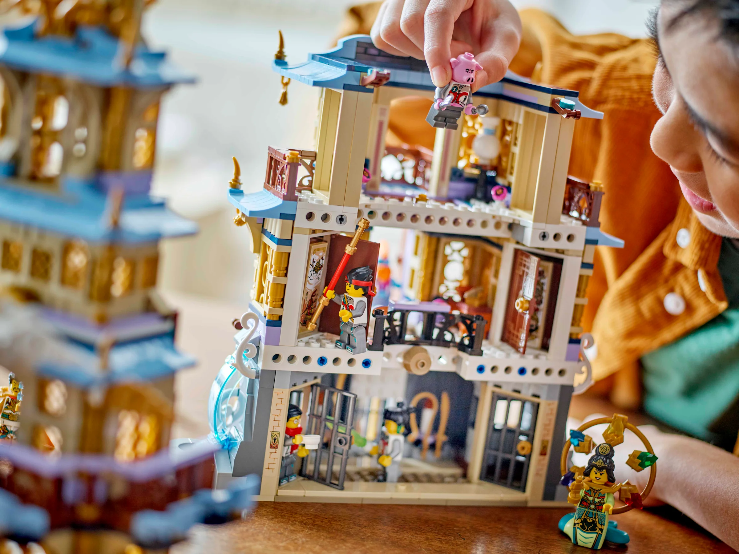 Copil interacționând cu setul LEGO 80058 Pagoda Celestă, explorând funcțiile și minifigurinele.