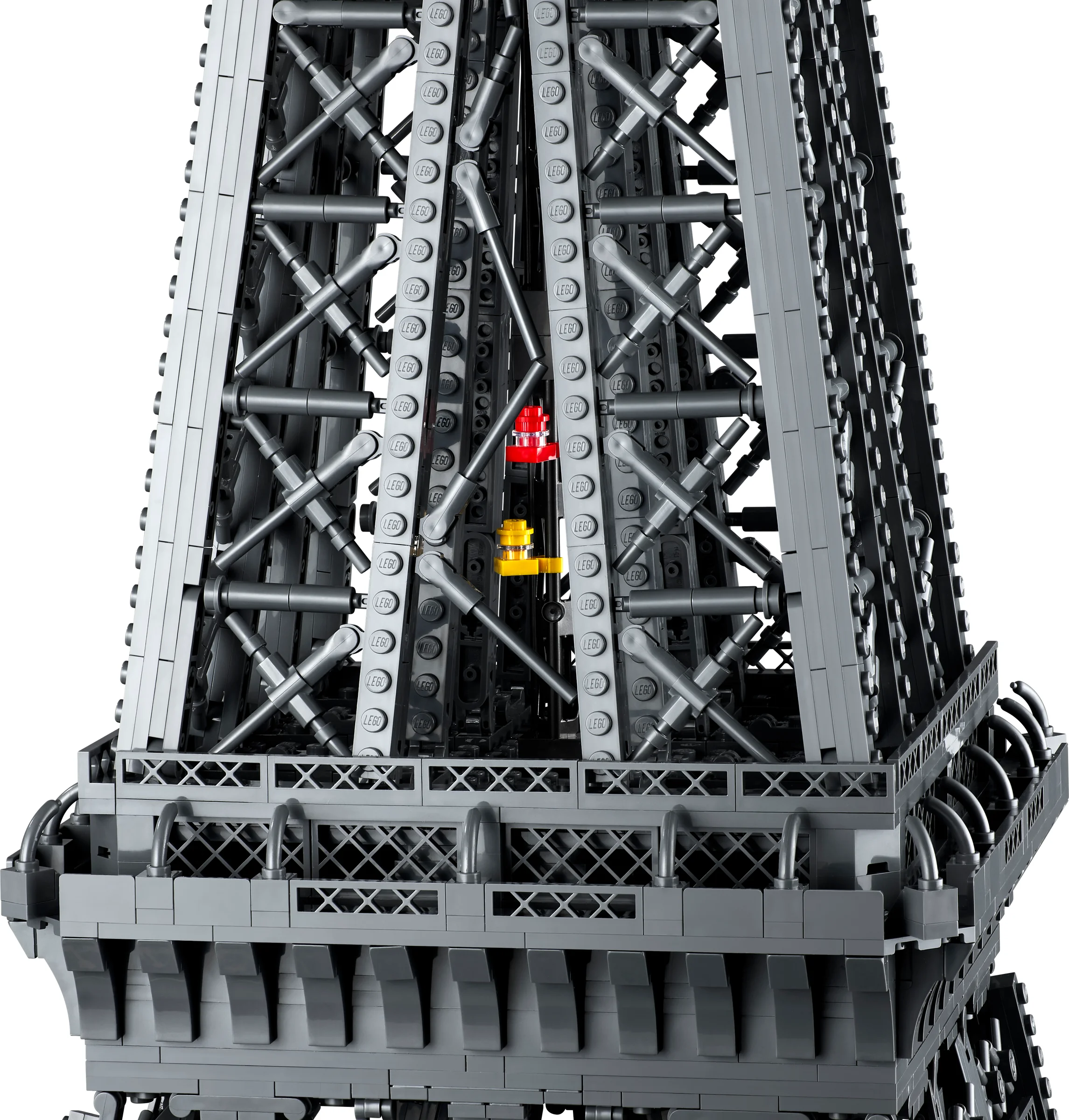 Detaliu al structurii Turnului Eiffel LEGO, cu elemente metalice și marcaje roșii și galbene.