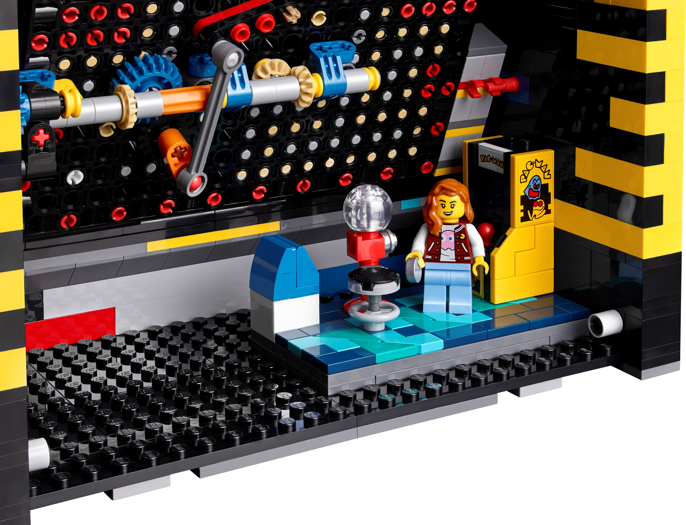 Interiorul detaliat al arcadei PAC-MAN LEGO, cu minifigurina și mecanismele interne.