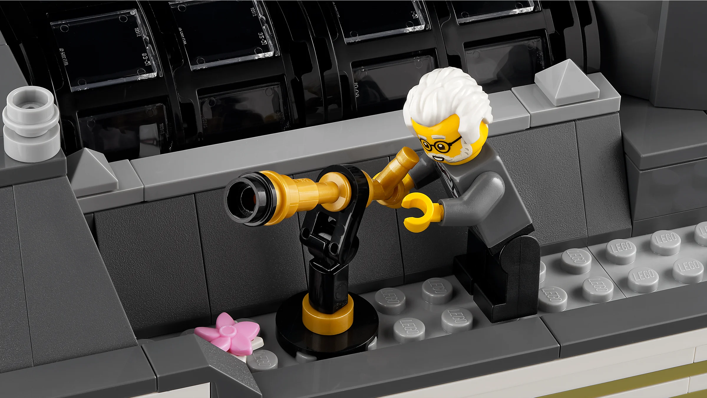 Prim-plan cu o minifigurină privind printr-un telescop auriu în Muzeul de Istorie Naturală LEGO.