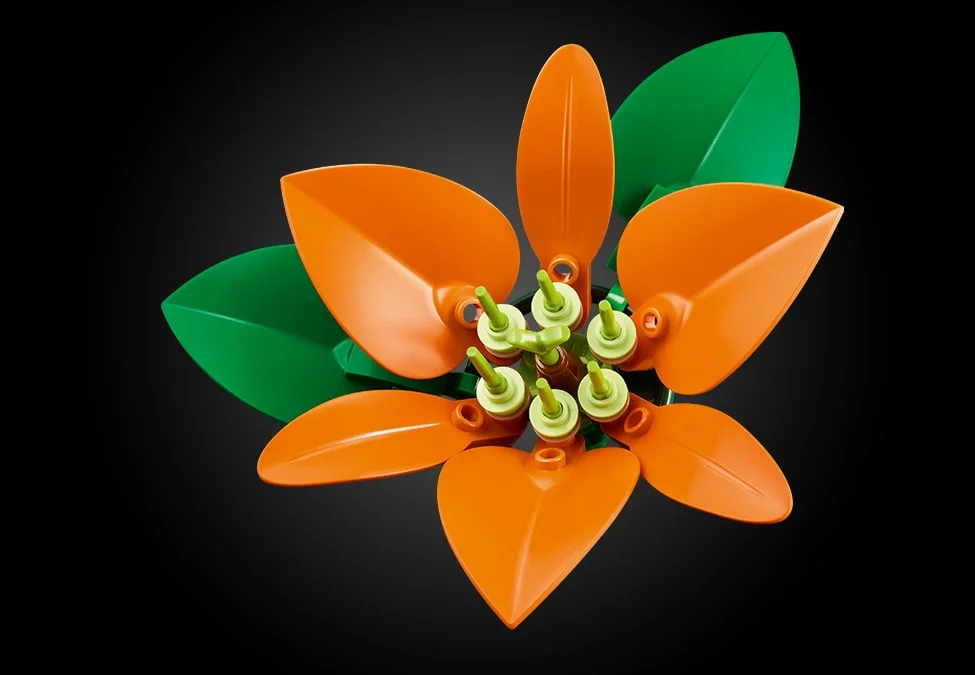 Aranjament floral LEGO cu petale portocalii și frunze verzi, detaliu de aproape.