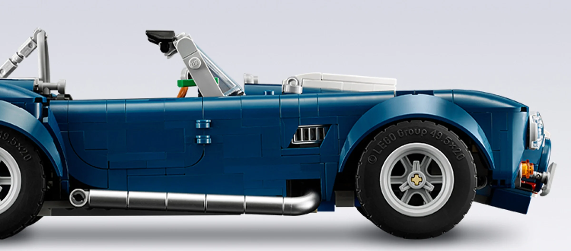 Detaliu lateral al modelului LEGO Shelby Cobra albastru, evidențiind designul și roțile.