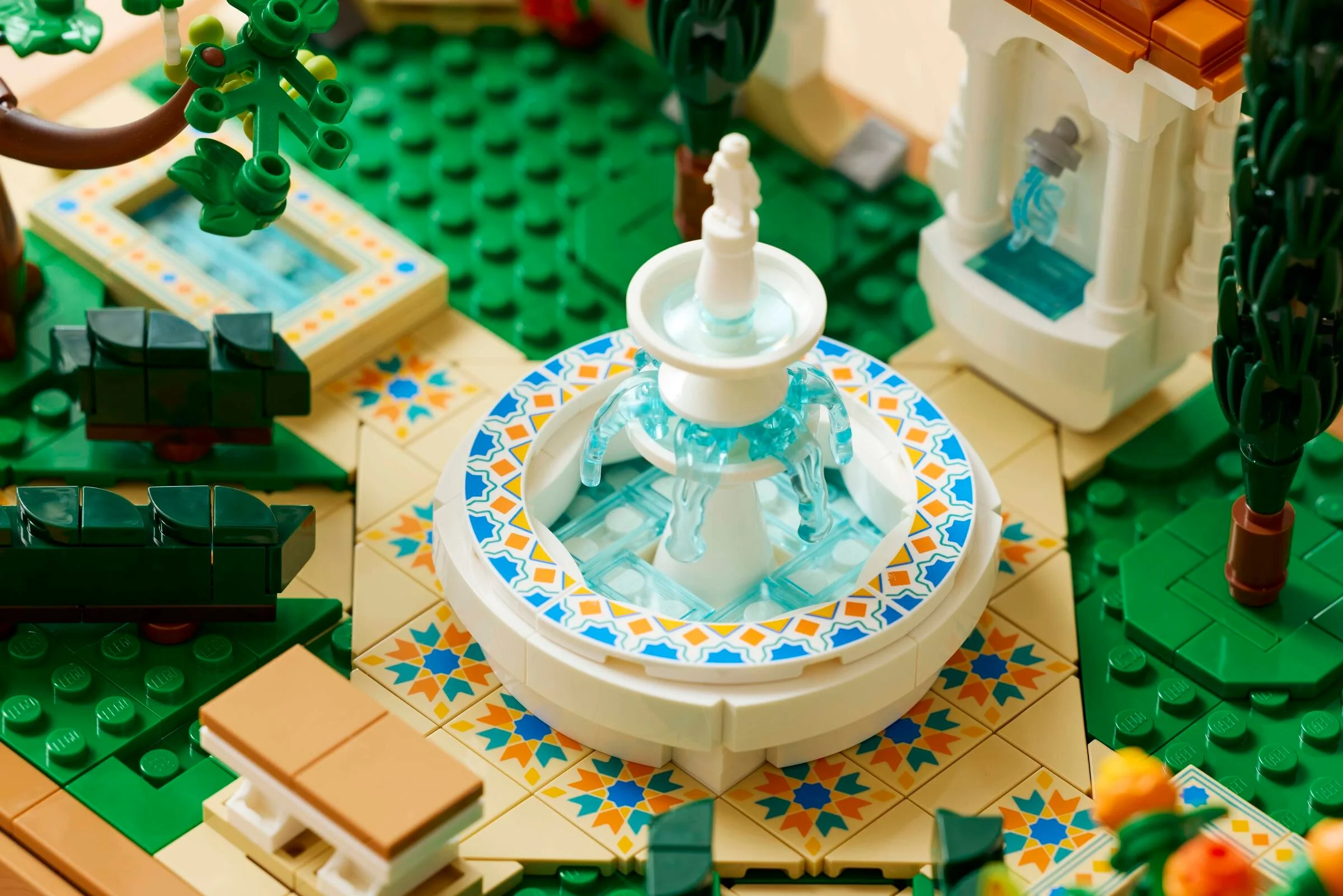 Imagine detaliată cu fântâna arteziană, piscină și elemente decorative ale grădinii LEGO Icons.