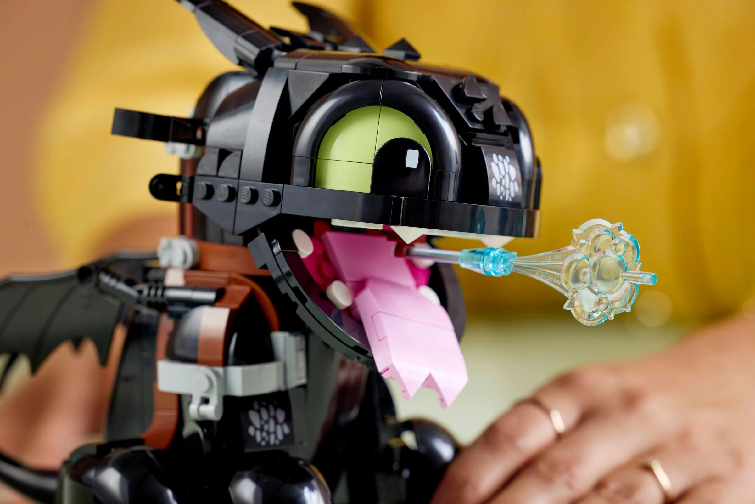 Prim-plan cu Toothless din LEGO, scoțând flăcări albastre. Detaliu captivant.